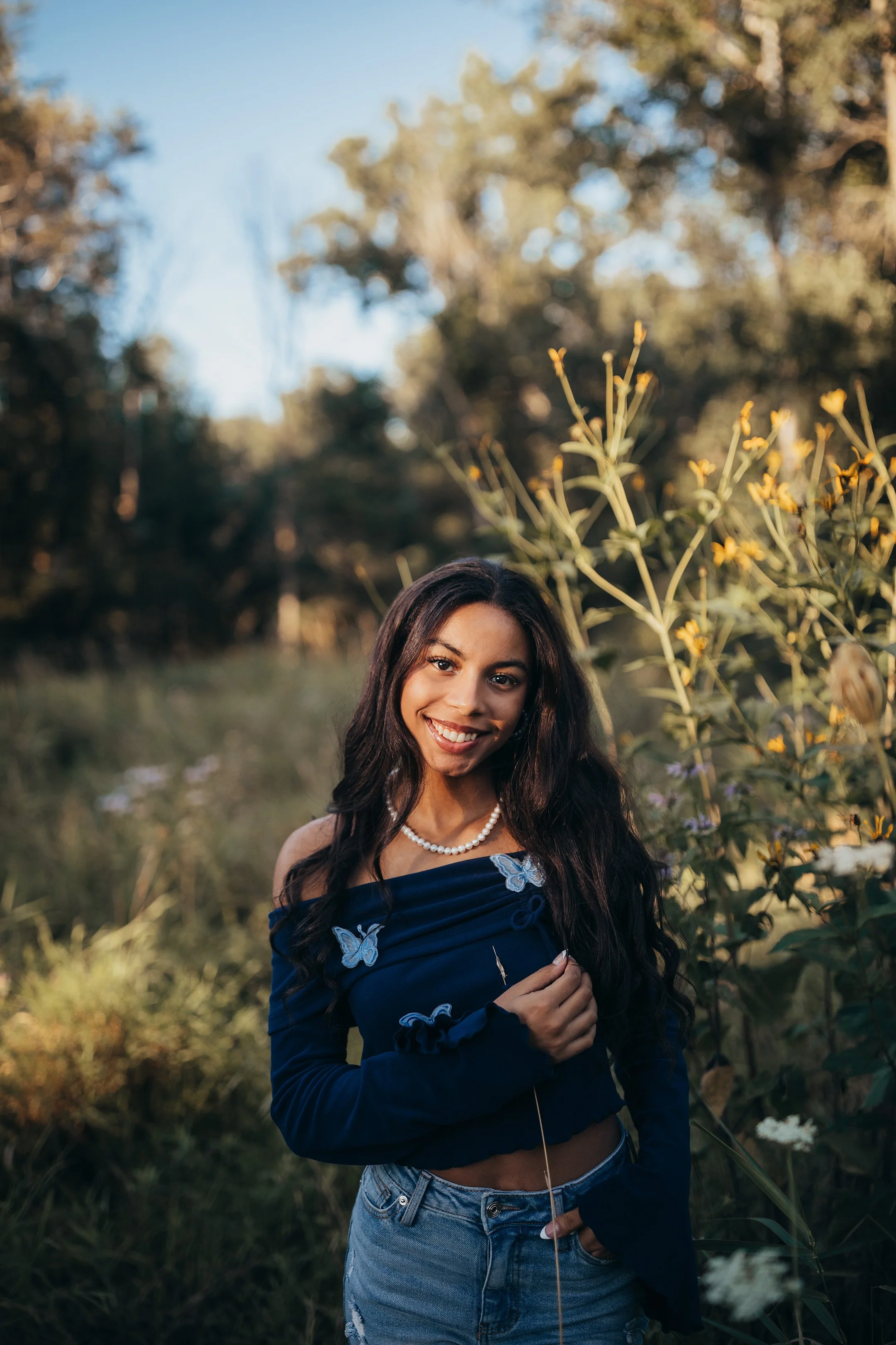 Senior portrait in a flower field during golden hour in Batavia, NY
