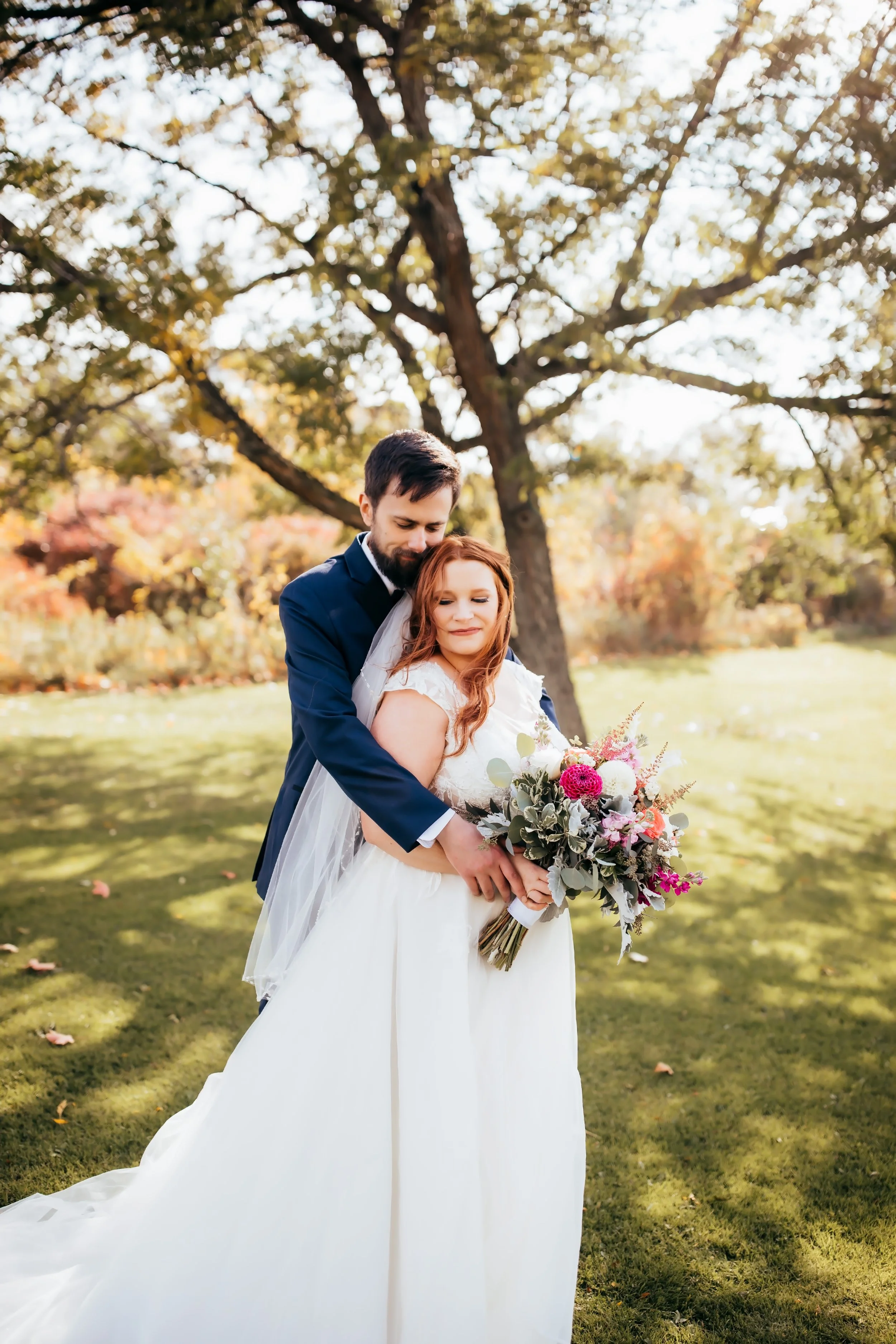 Outdoor wedding portrait in Western NY with a bride and groom embracing in a quiet moment during golden hour