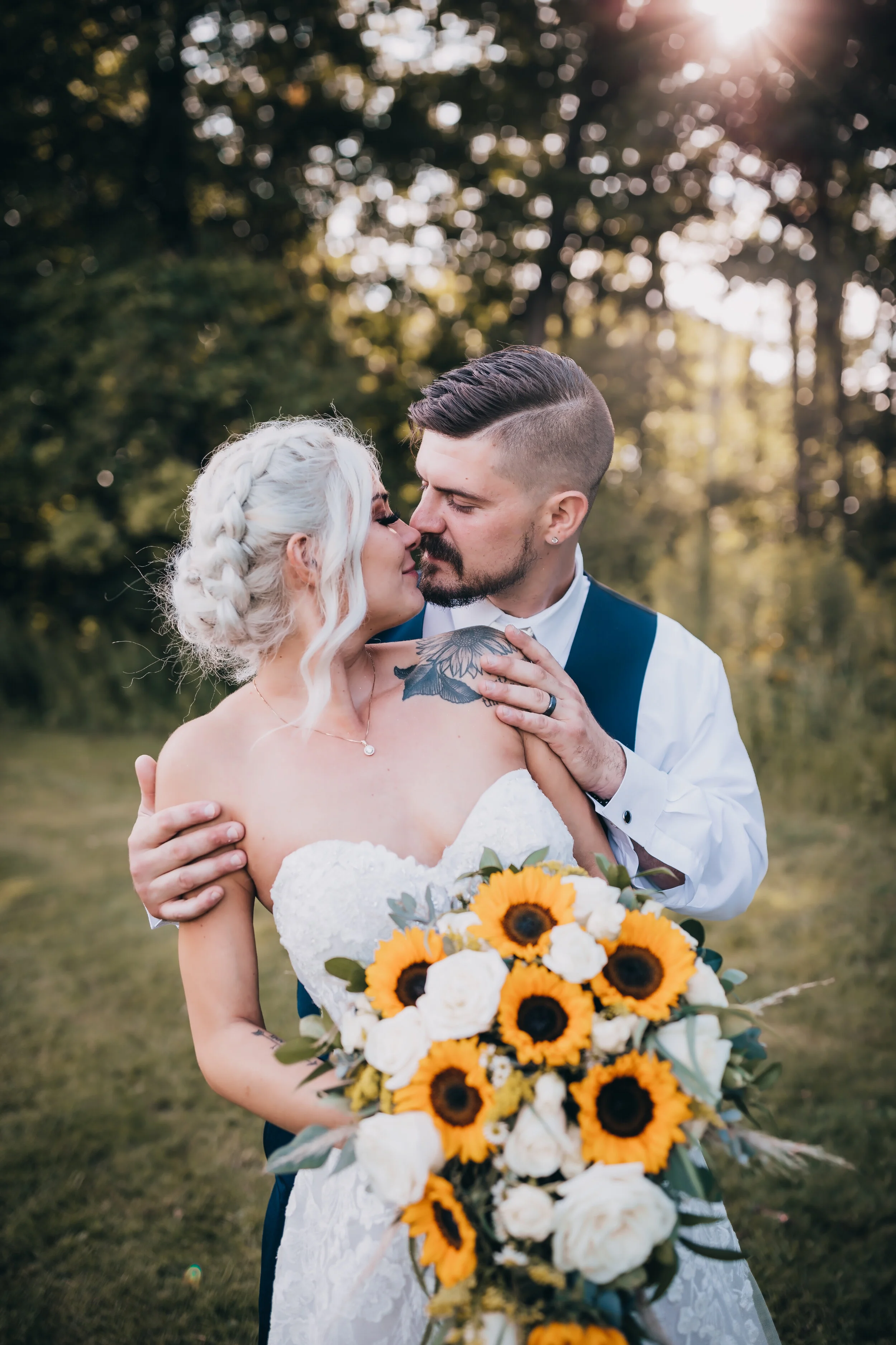 Outdoor wedding photography of a bride and groom sharing an intimate moment with a sunflower bouquet