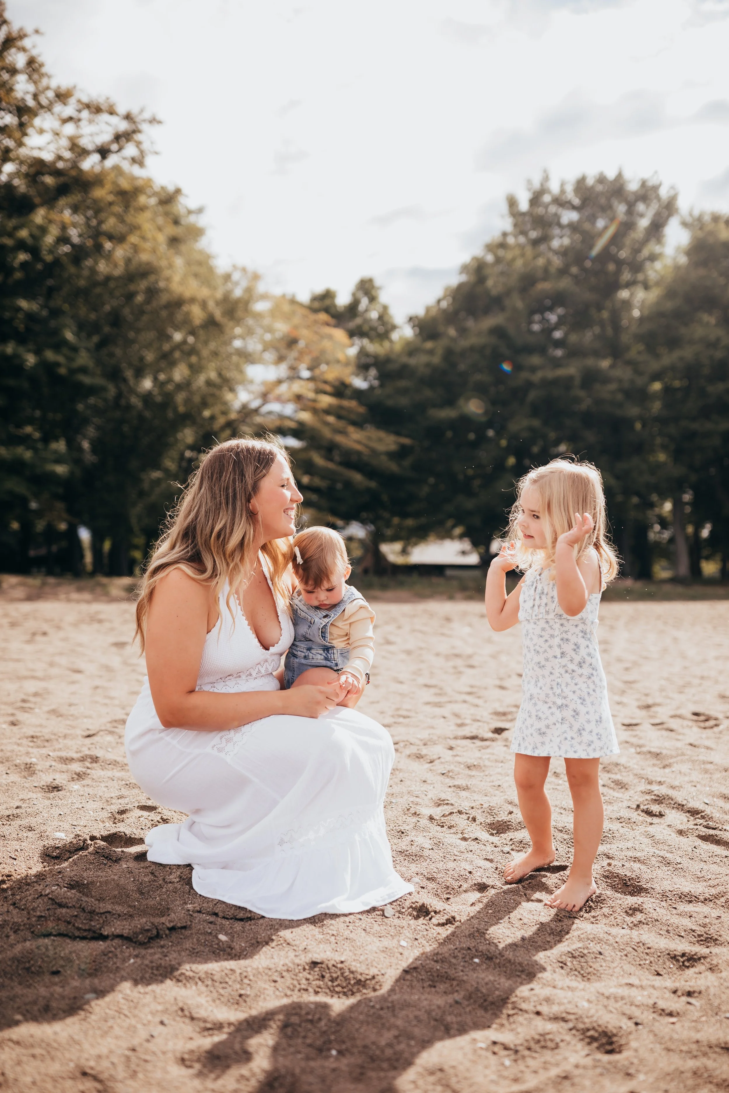 Candid family photo of mother with her daughters during a relaxed beach session at Hamlin Beach State Park