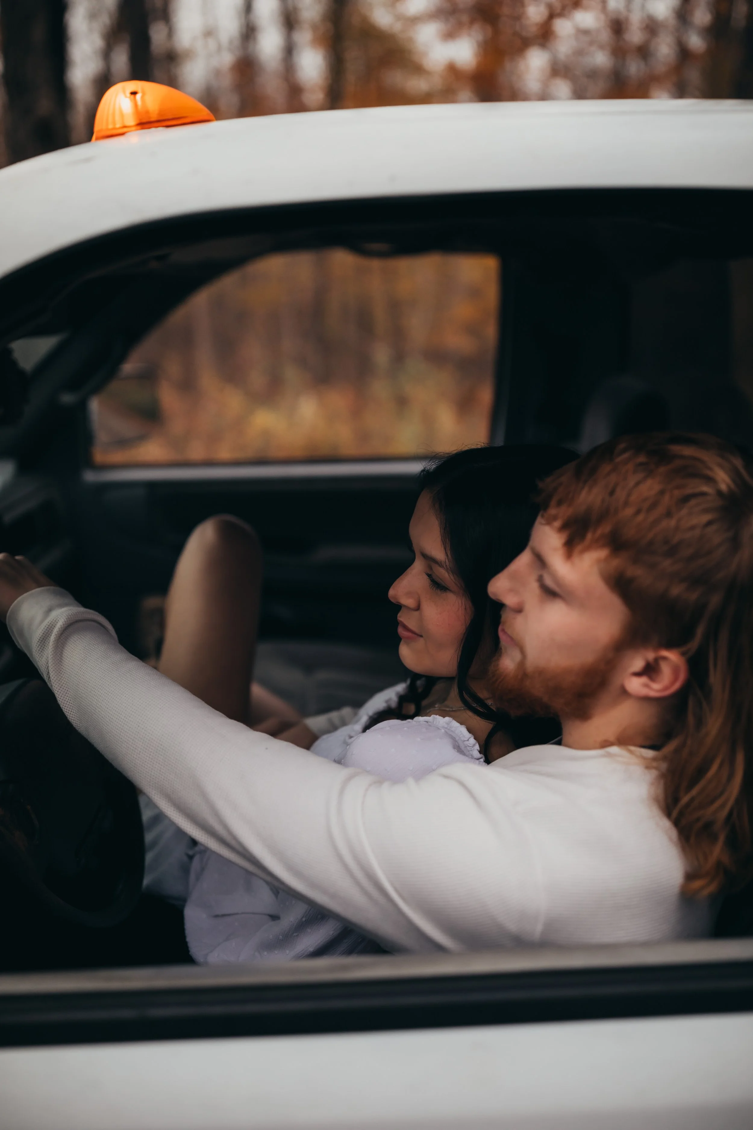 Couples photography session snuggling in the truck in the fall