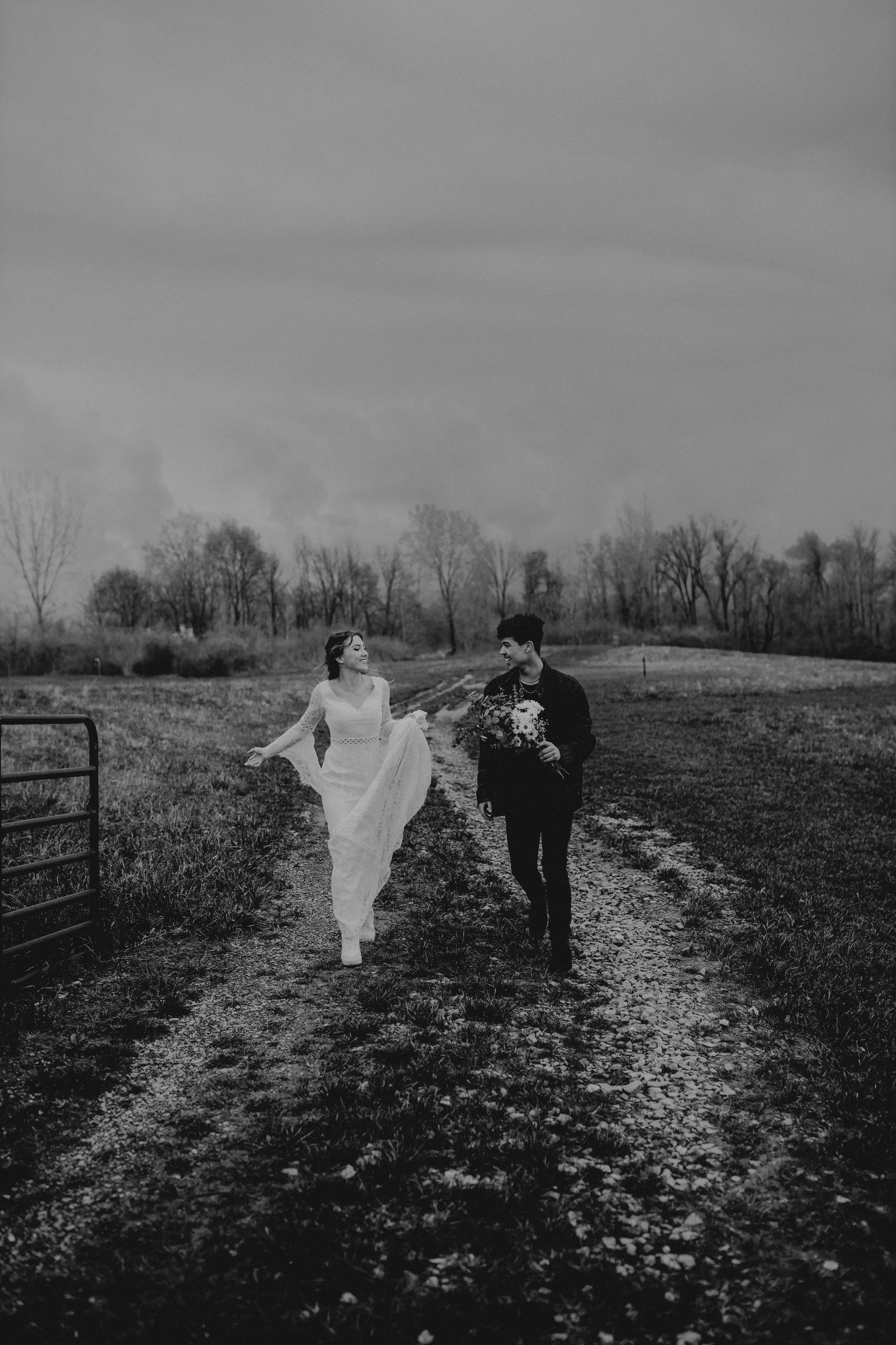 Black and white portrait of a couple who just eloped and are looking at each other while running towards the bliss.