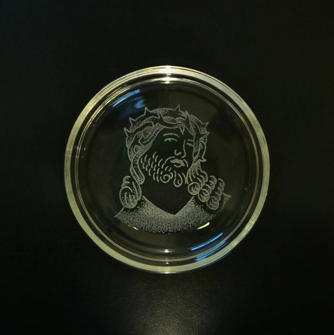Jesus portrait on a glass dish with a black background made by Harry king