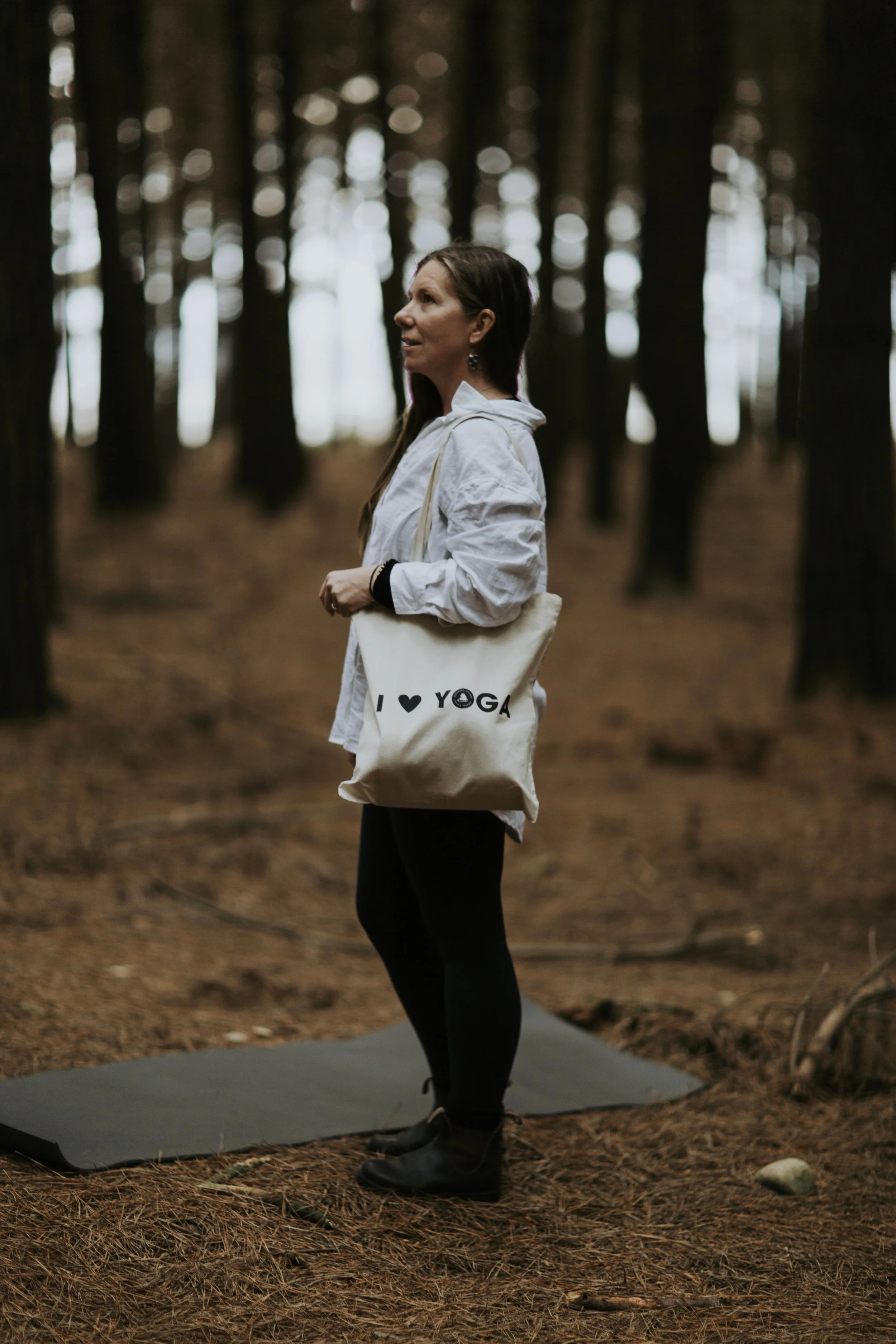 Hayley standing in the forest, representing commitment, presence, and professional practice