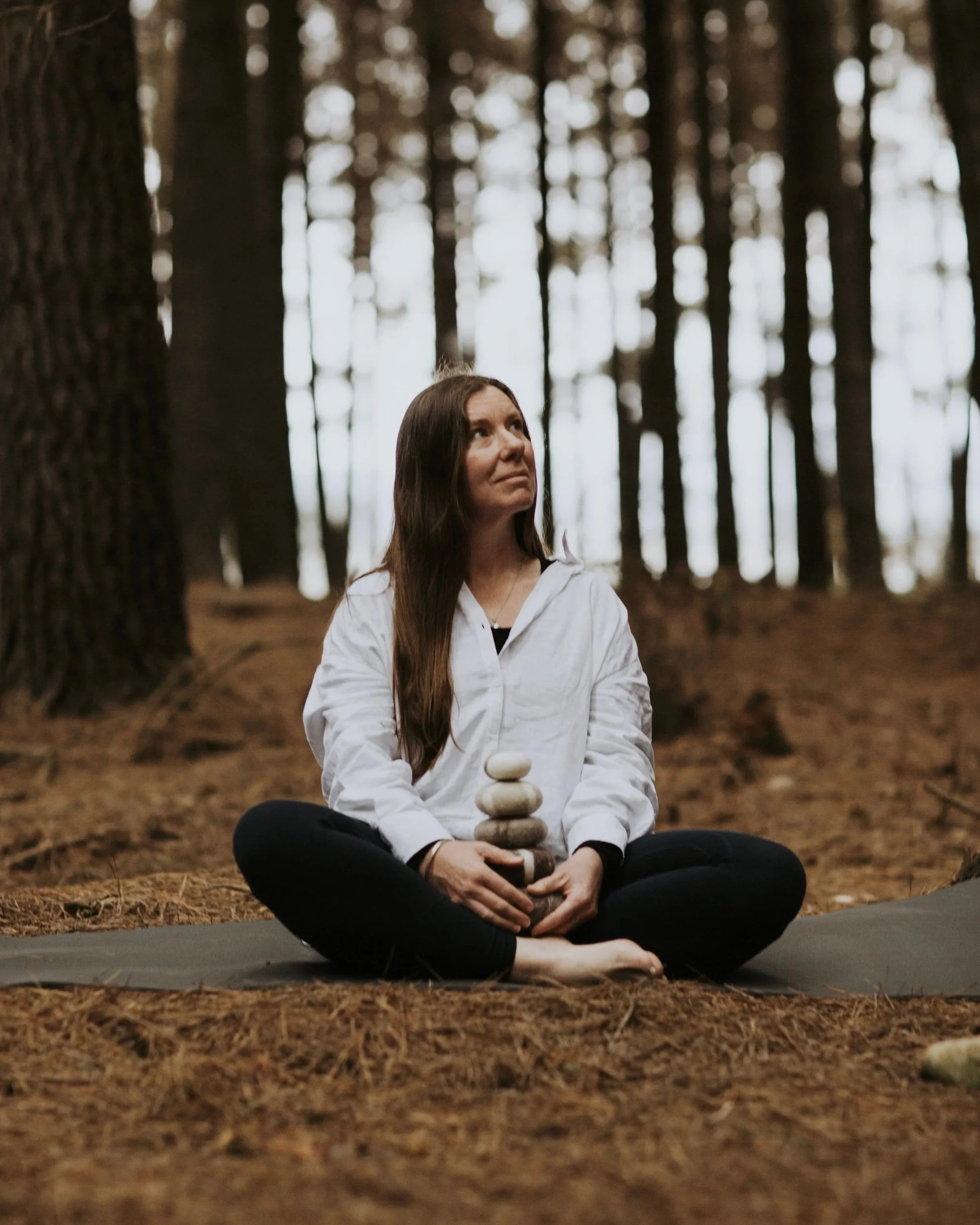 Hayley seated in the forest in quiet contemplation, embodying presence and grounding
