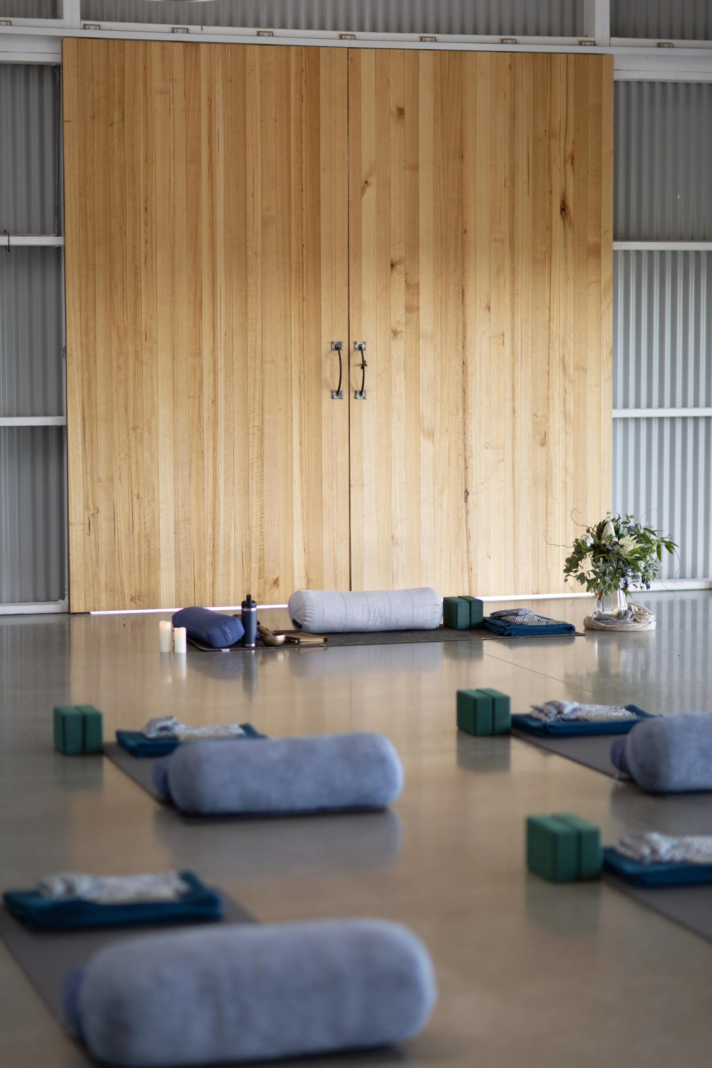 Mats and bolsters arranged to welcome participants into a retreat space