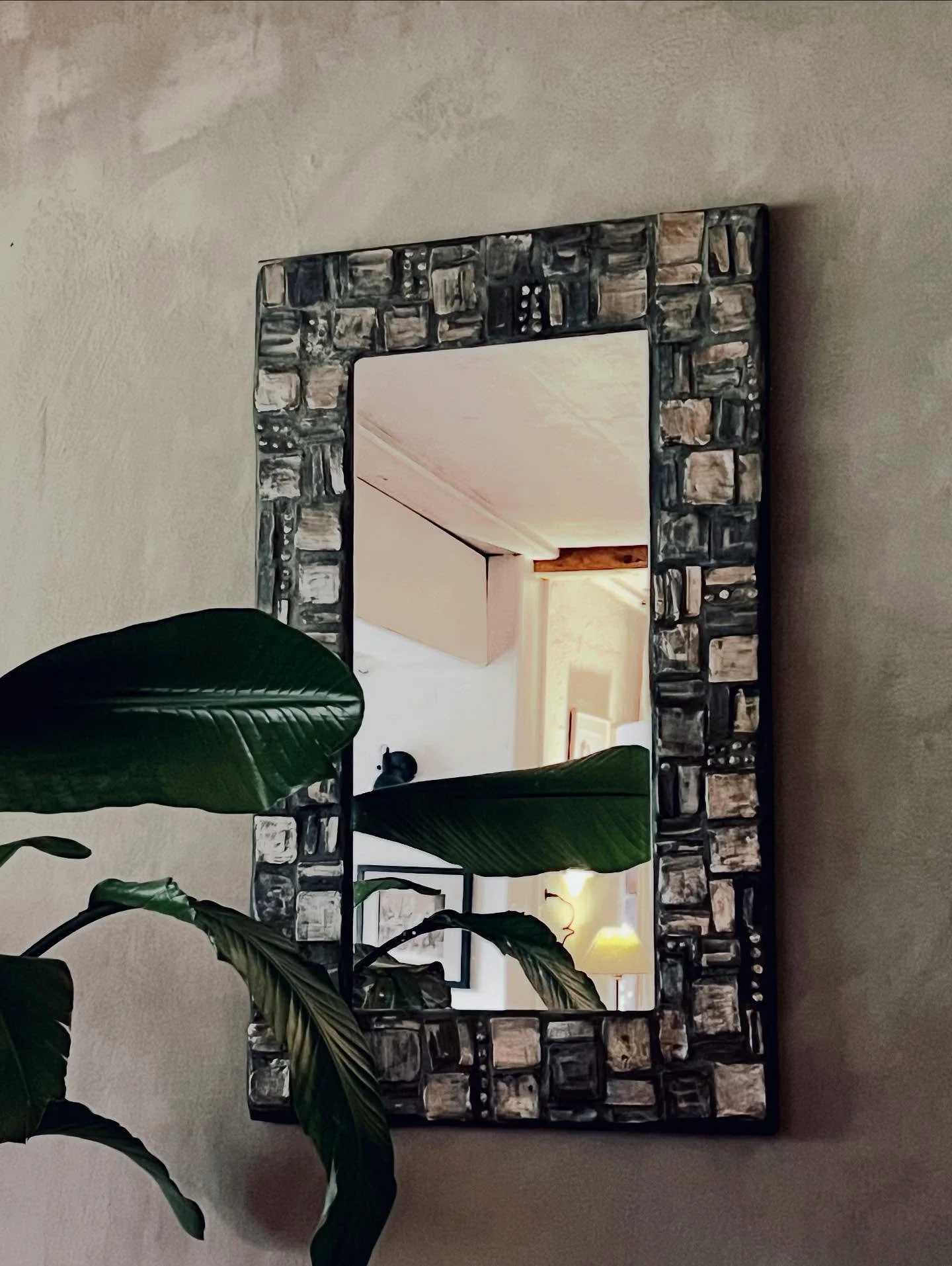 I hand crafted this mirror 15 years ago. I glazed my tiles with a bronze silver luster glaze that I still adore and used an anthracite grout.  The backing is super heavy marine ply that I sealed 3 times to make sure there would be no movement underne