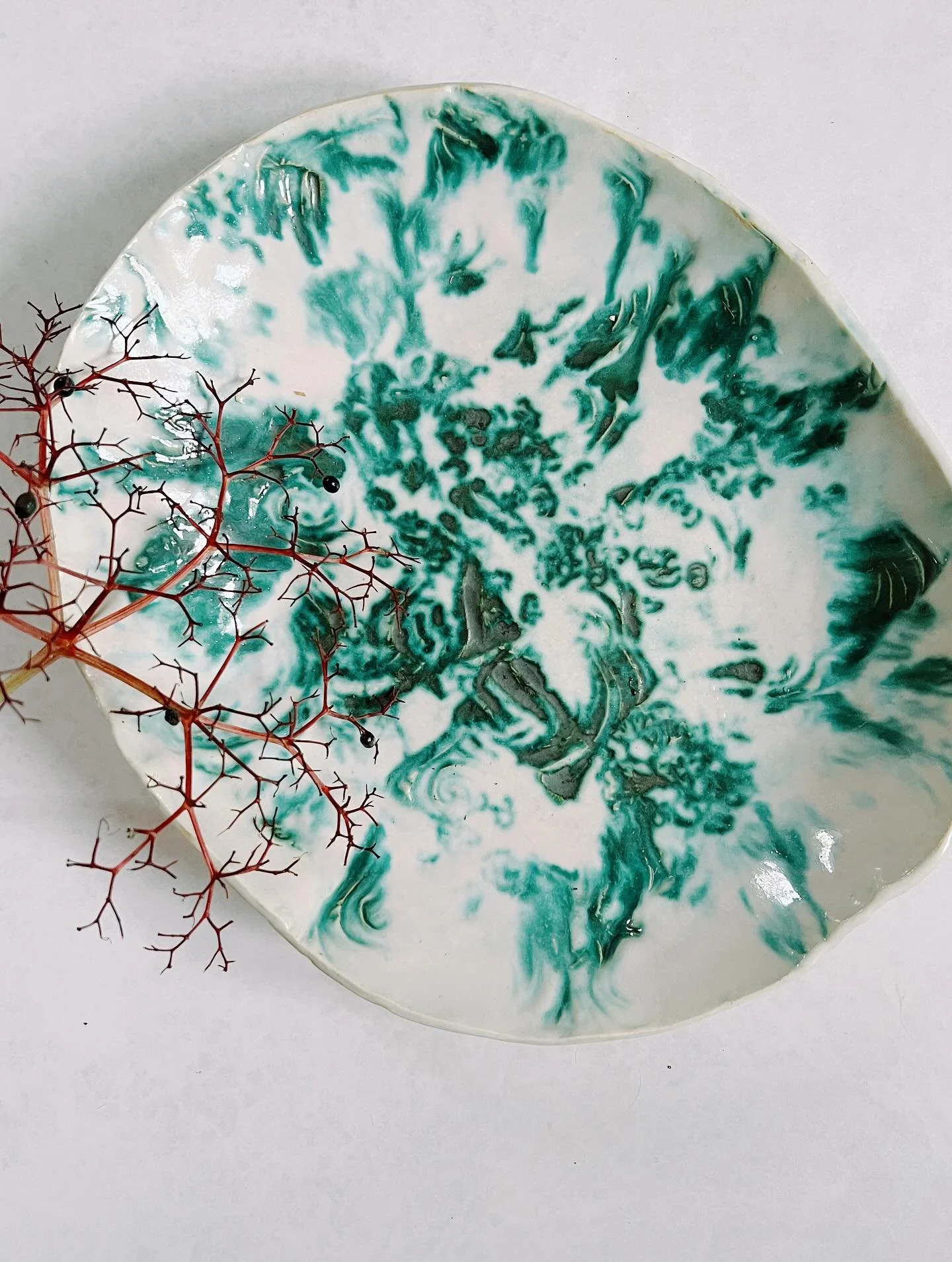 This platter came out of the kiln in the most unexpected way.

I had decided to experiment with a copper wash I has mixed up and painted into the areas I had stamped the clay.  Then I glazed it with with a favorite glaze but added some titanium to th