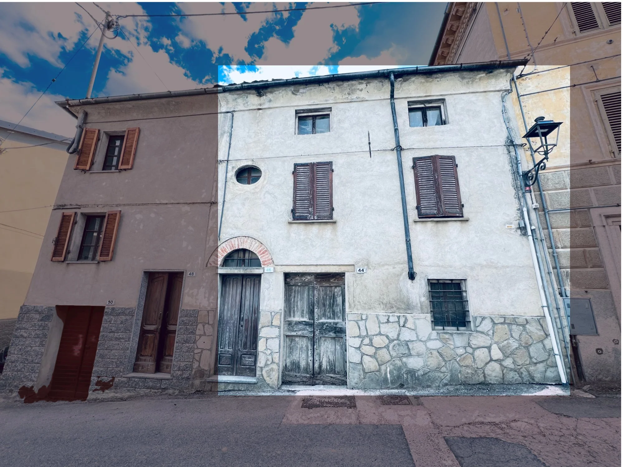 Old three-story building with a mix of stone and stucco facade, wooden shutters on windows, and a weathered wooden door, narrow street in a European town.