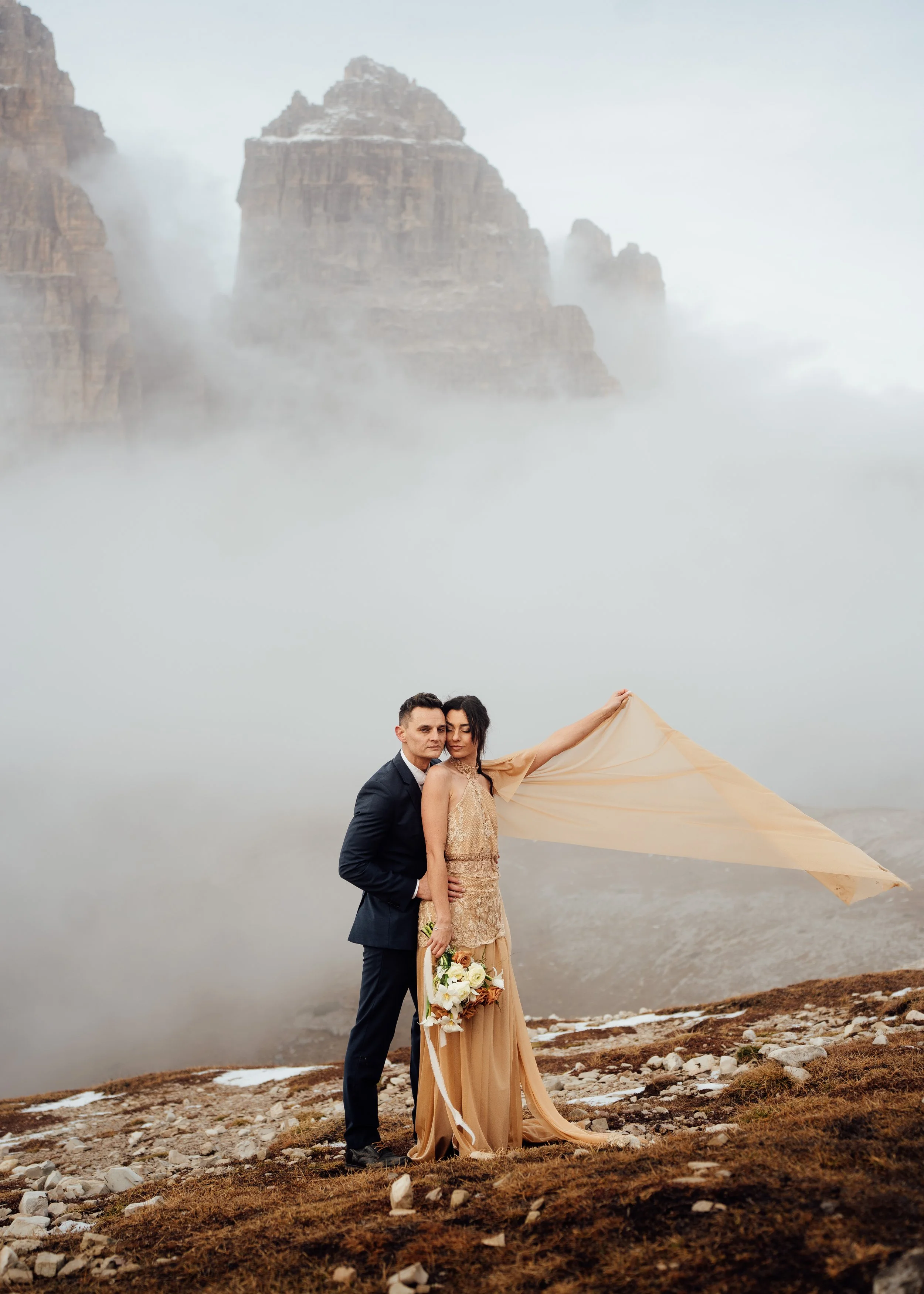 couple eloping at tre cime di lavaredo sunset wind blowing bride wedding dress