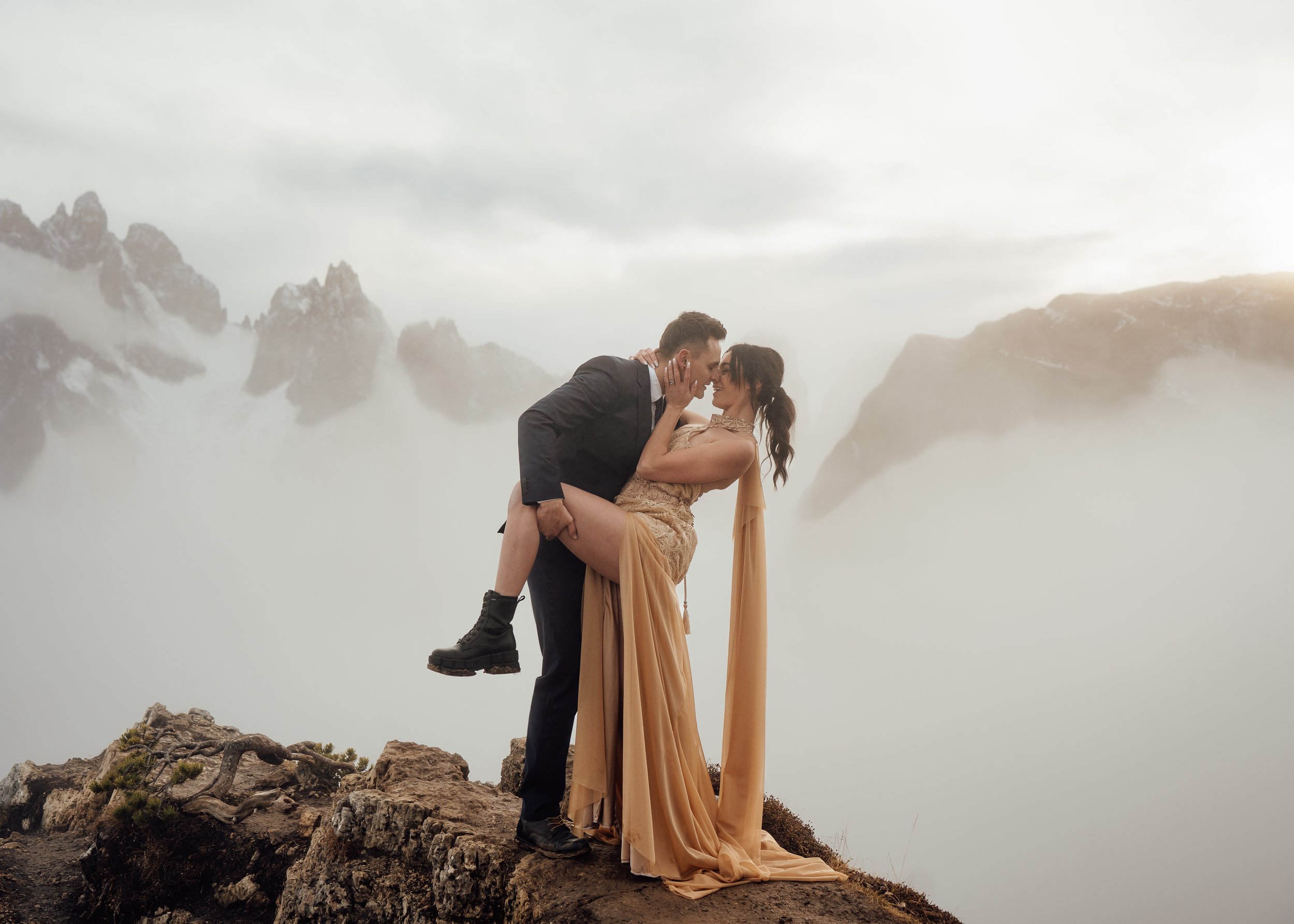 couple eloping at cadini di misurina husband dipping wife and kissing at famous viewpoint