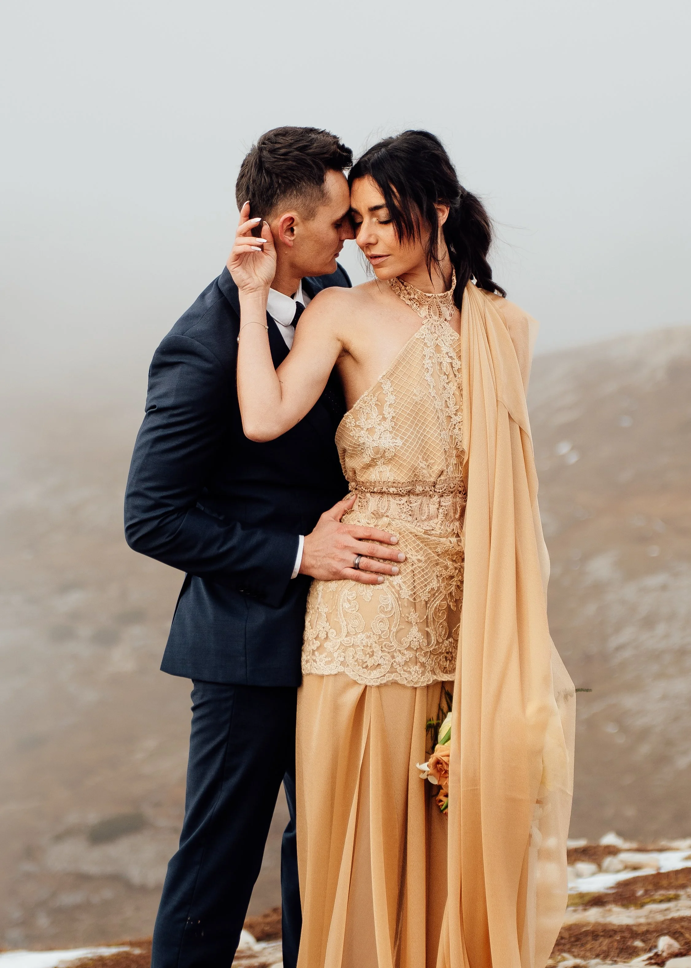 couple eloping at tre cime di lavaredo in wedding clothes embracing