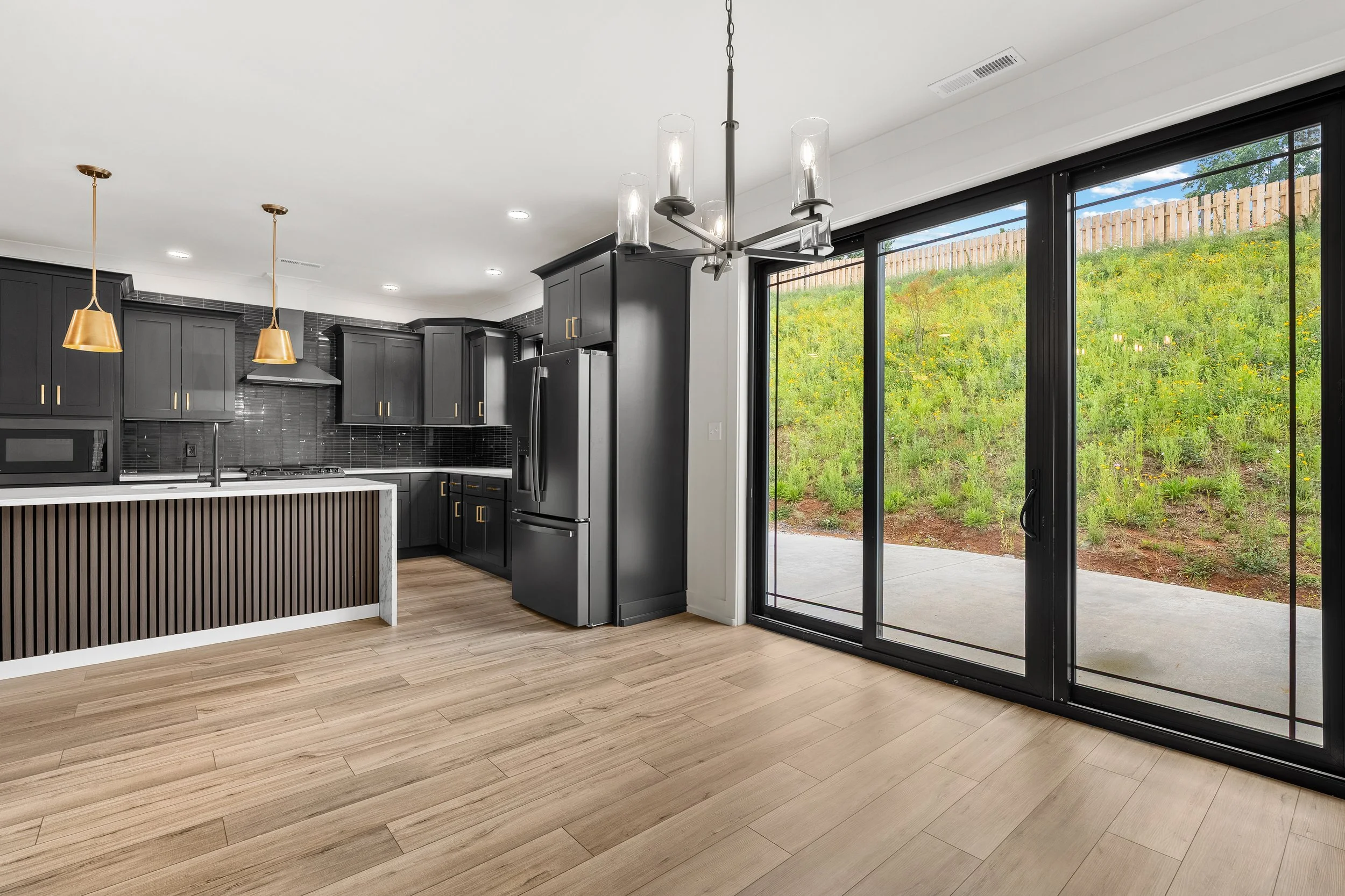 Modern bathroom with dual vanity and a walk-in shower featuring black and gray vertical tile walls and a window in the shower ceiling.