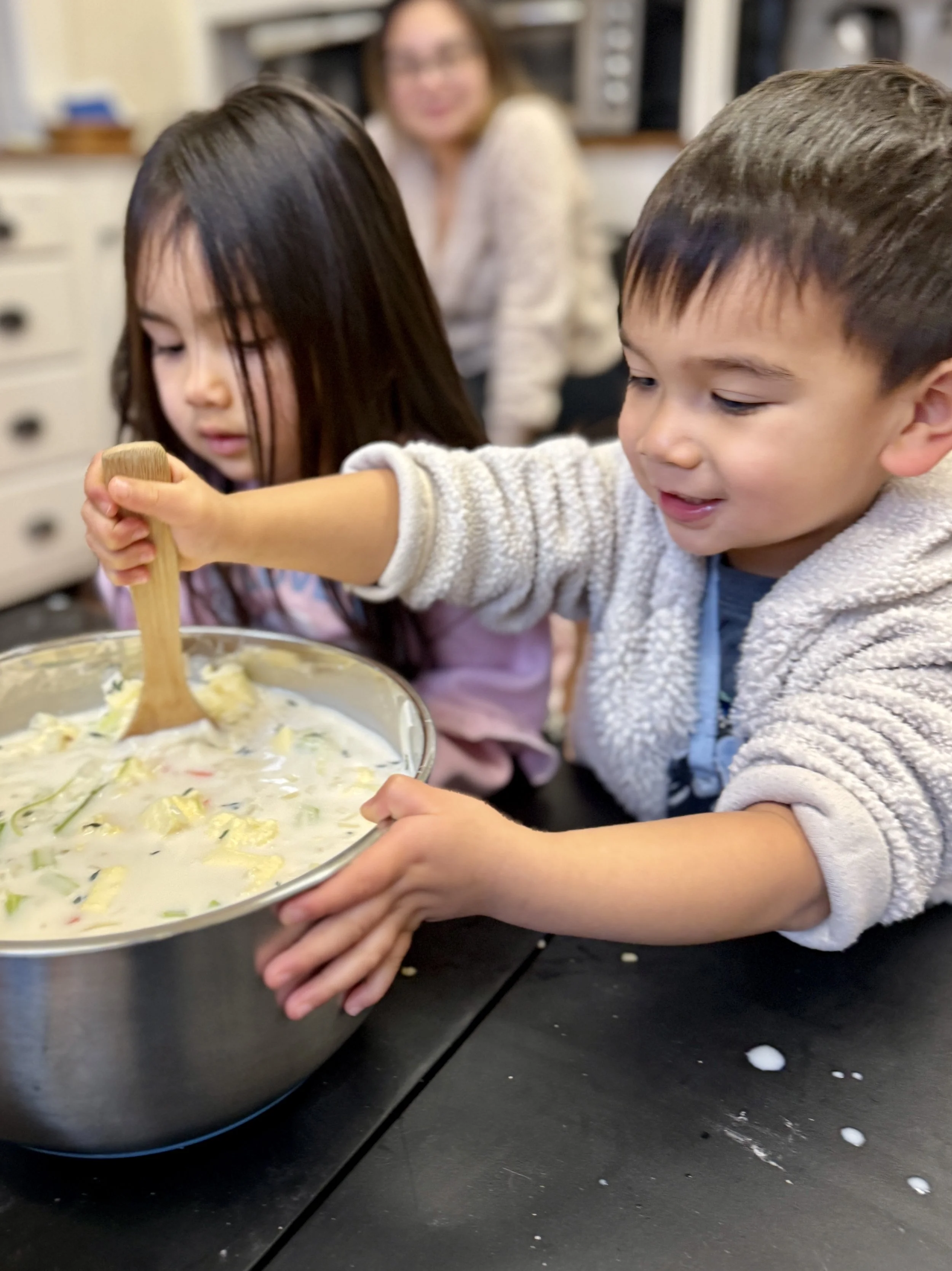 children smiling, cooking, kitchen tools, making food, Montessori space