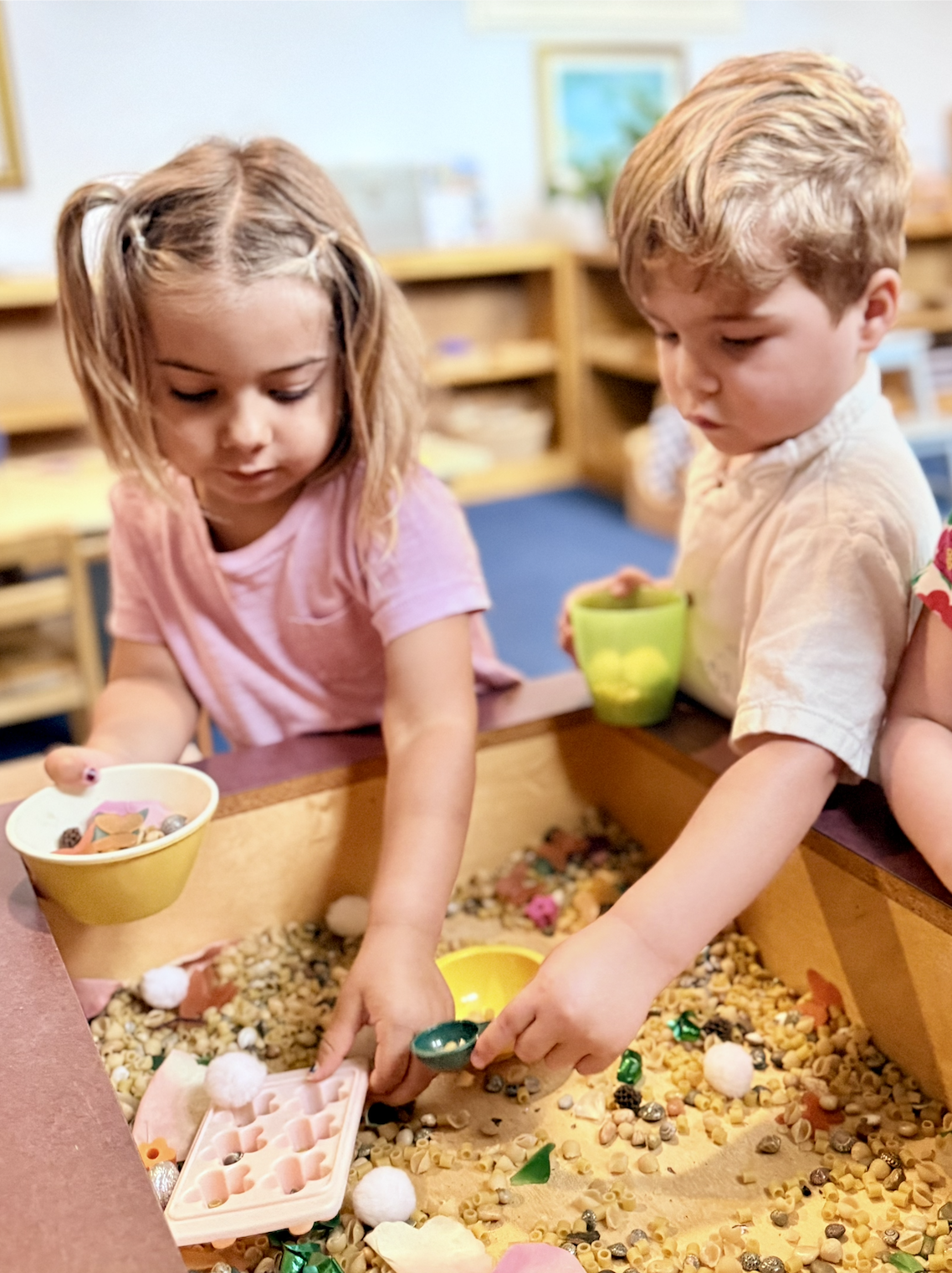 children playing in sensory bin, Montessori space