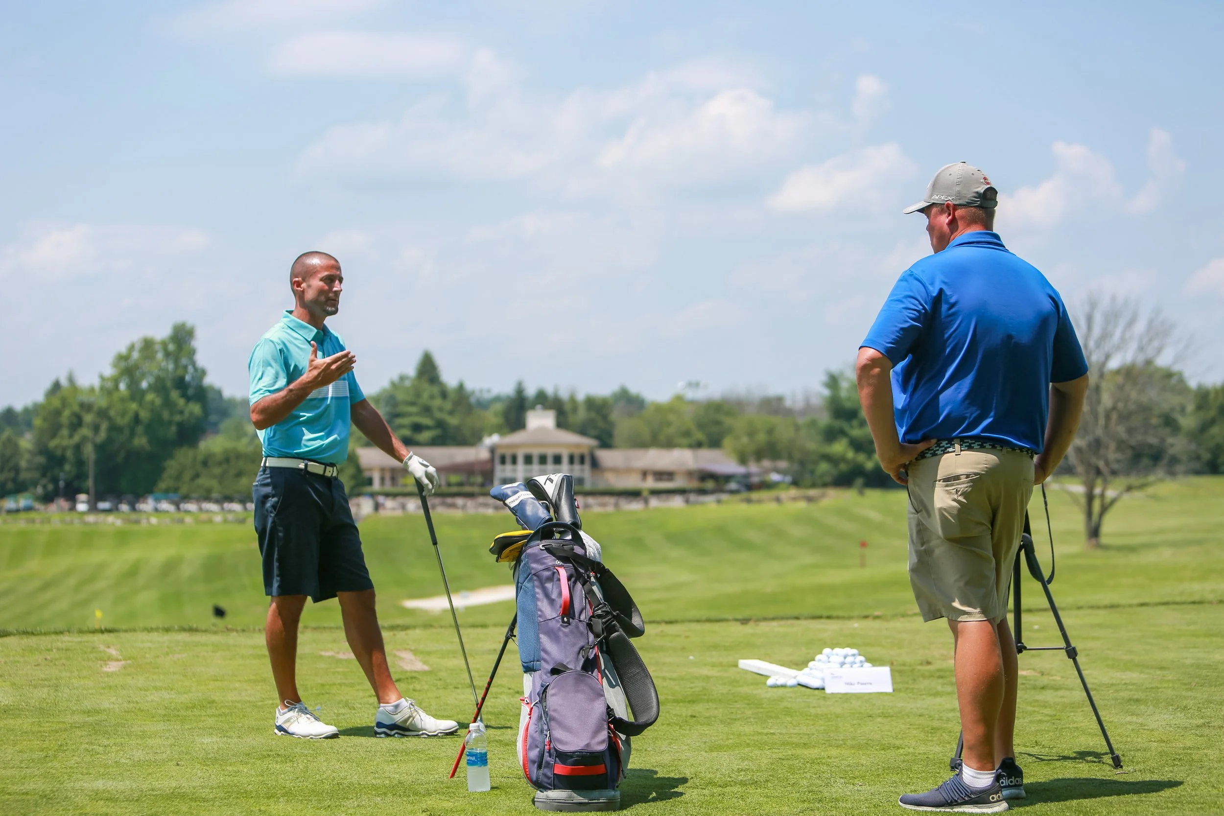 Mike Puorro taking a golf lesson with Tom Reynolds