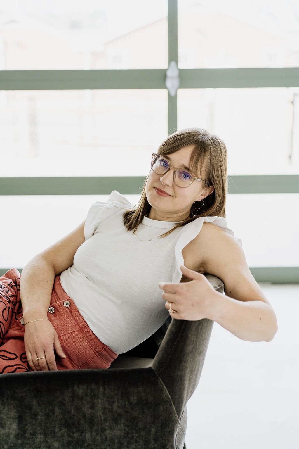 Postpartum therapist in Denver, Leanne Morton, relaxing on a couch.