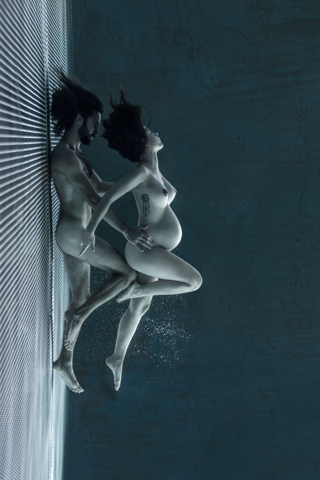 photographie d'une future maman sous l'eau retenant son souffle dans une piscine en inox
