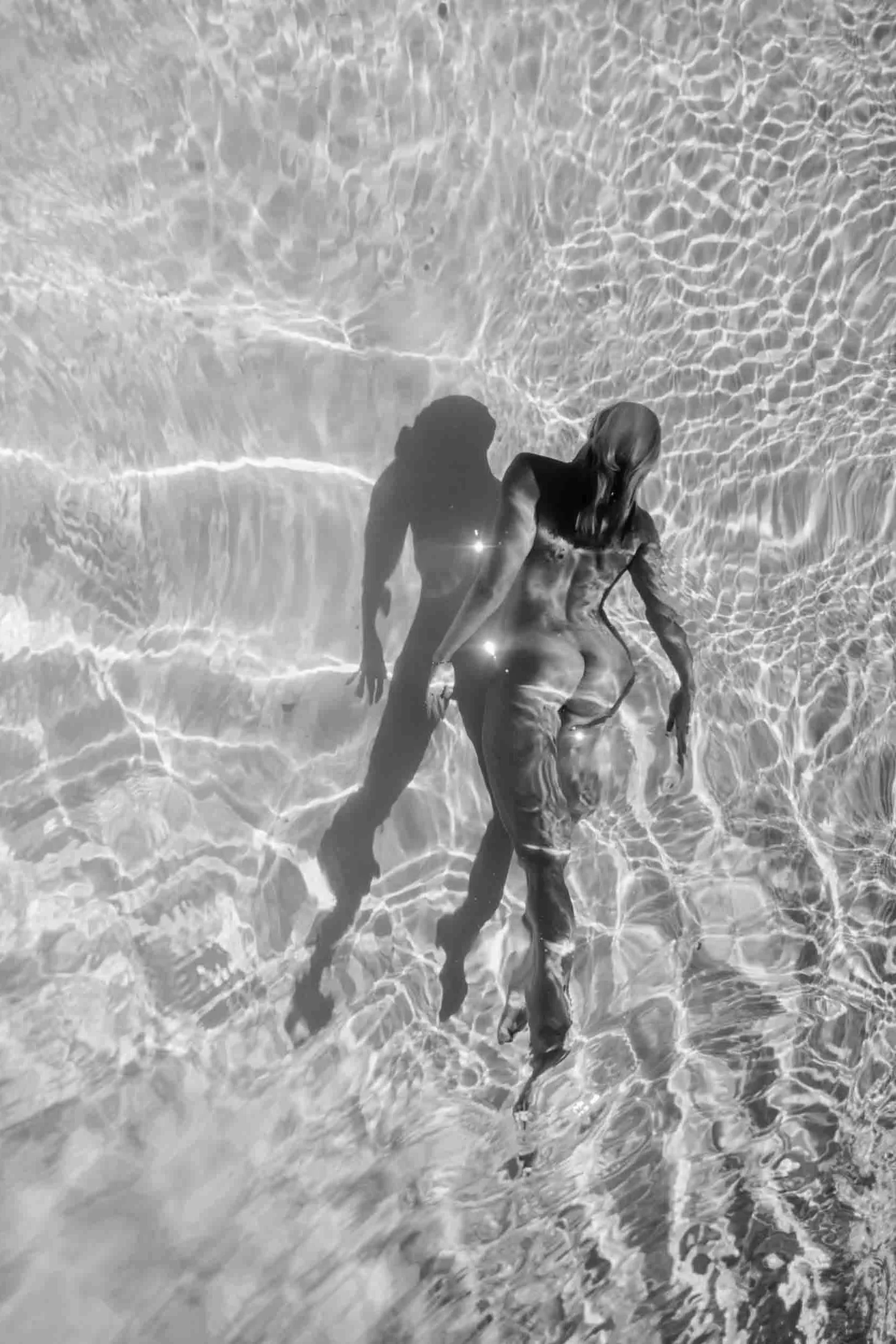 femme portant la vie, nageant dans une piscine au soleil, nue