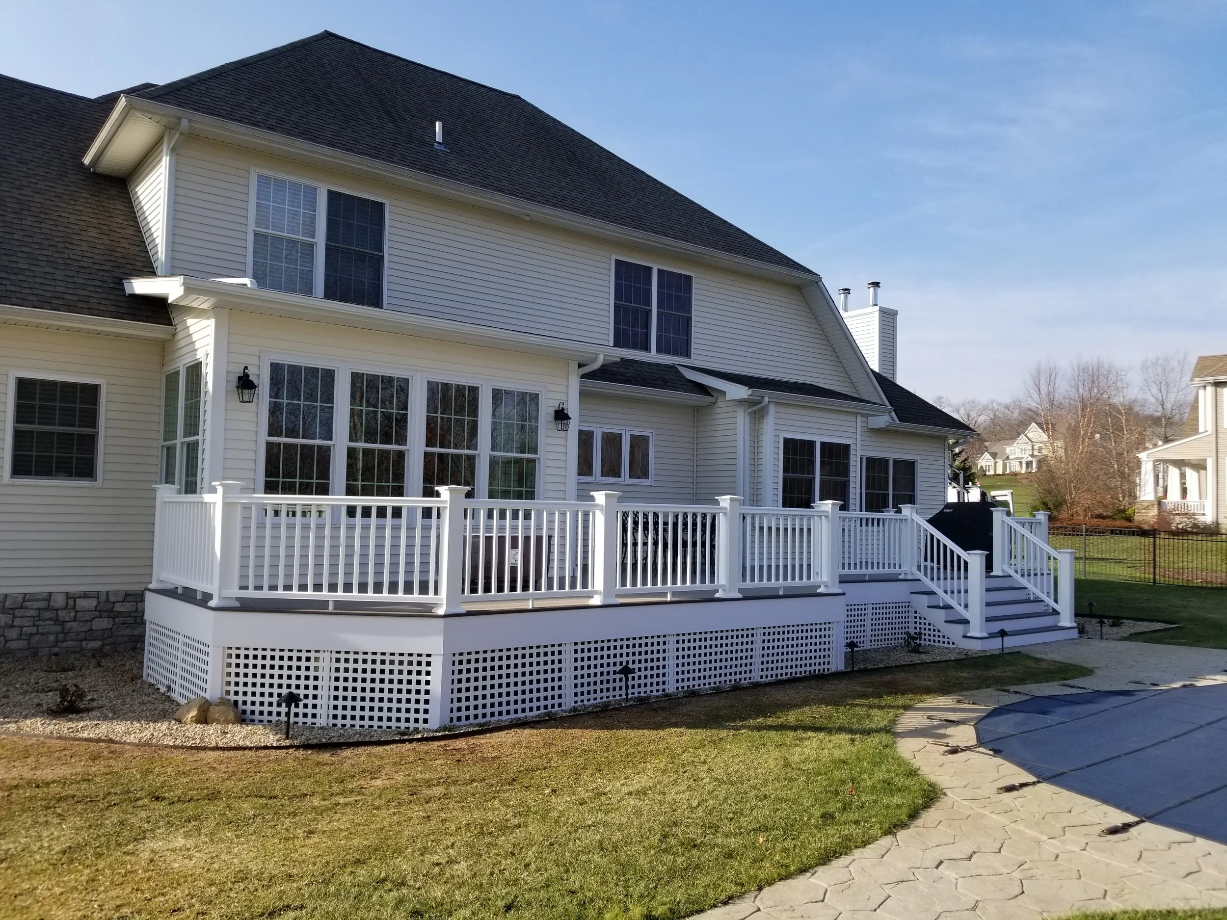 Completed sunroom project in East Lyme shows a bumped out living room addition and expanded deck area.