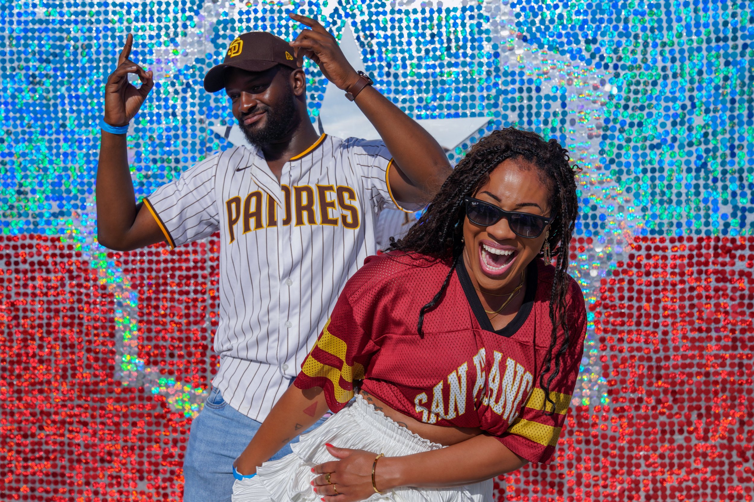 two people smiling in front of Juneteenth flag