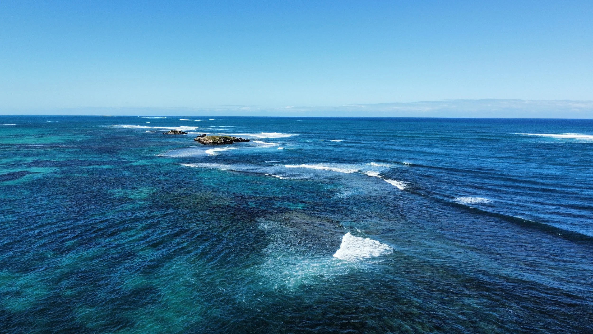 Aerial view of offshore limestone reefs and rocky islands in Jurien Bay Marine Park.