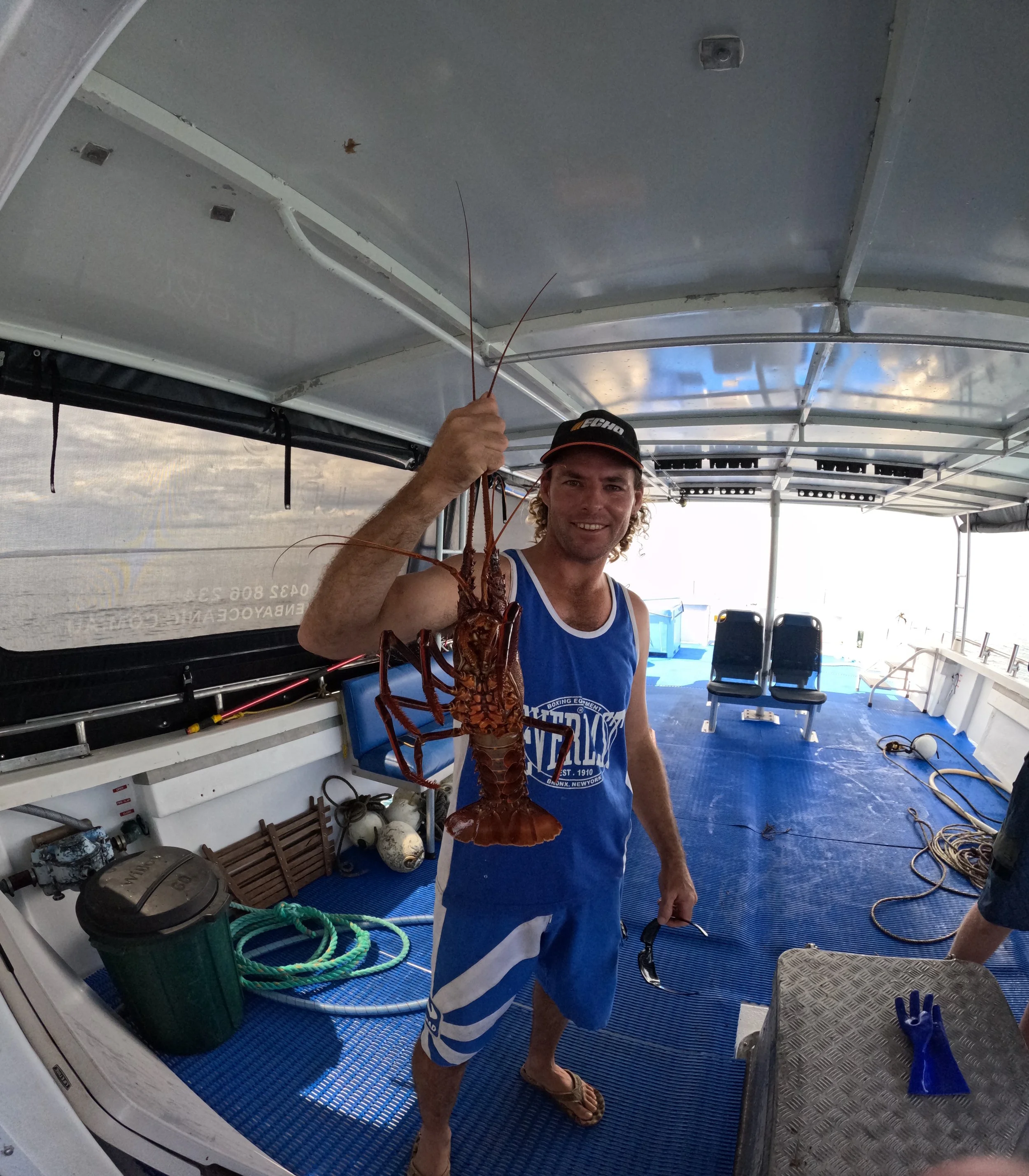 Recreational fisher holding a Western Rock Lobster aboard a boat in Jurien Bay, Western Australia.