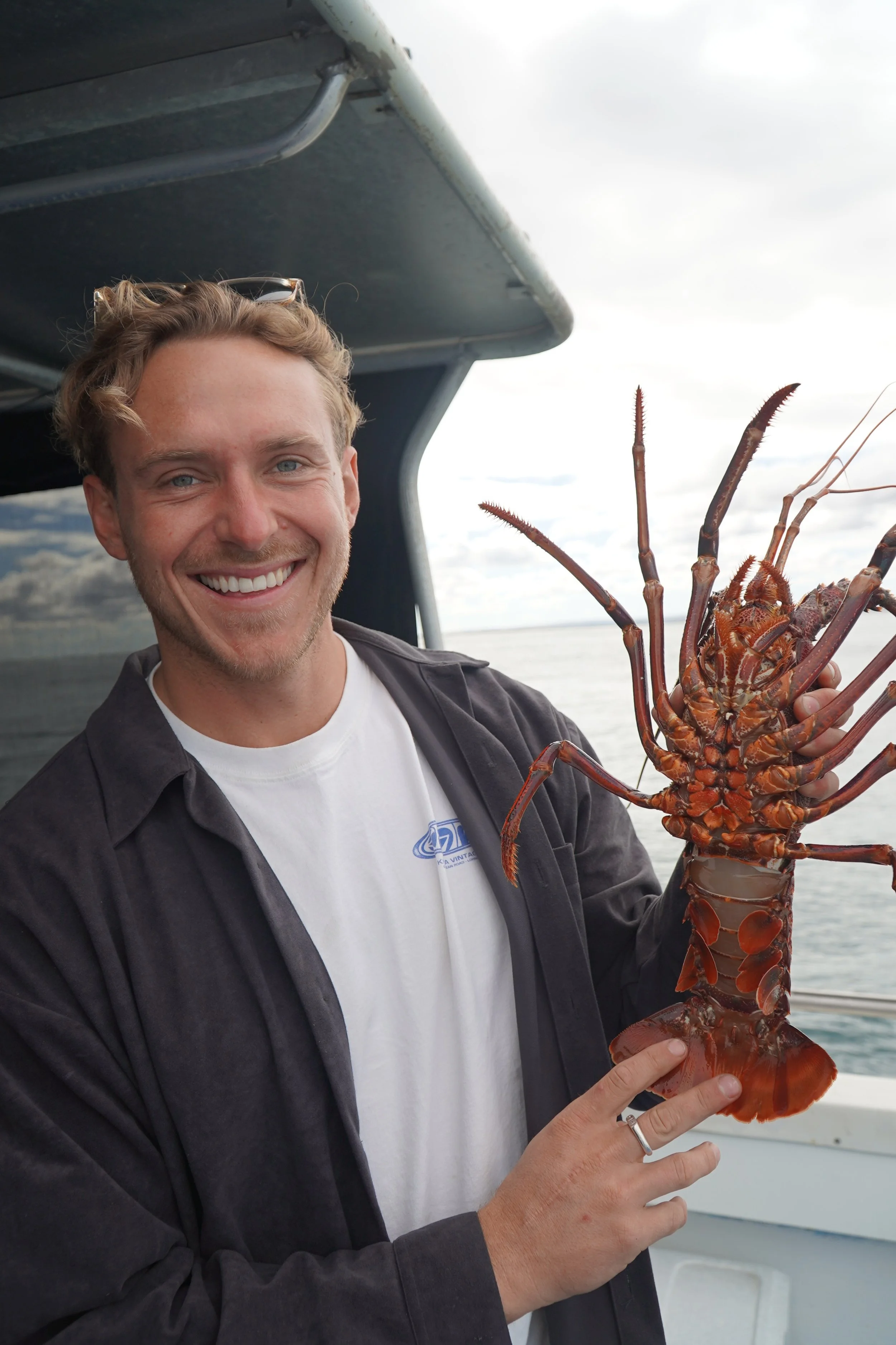 Guest holding a freshly caught Western Rock Lobster during a lobster catch and keep tour in Jurien Bay, Western Australia.
