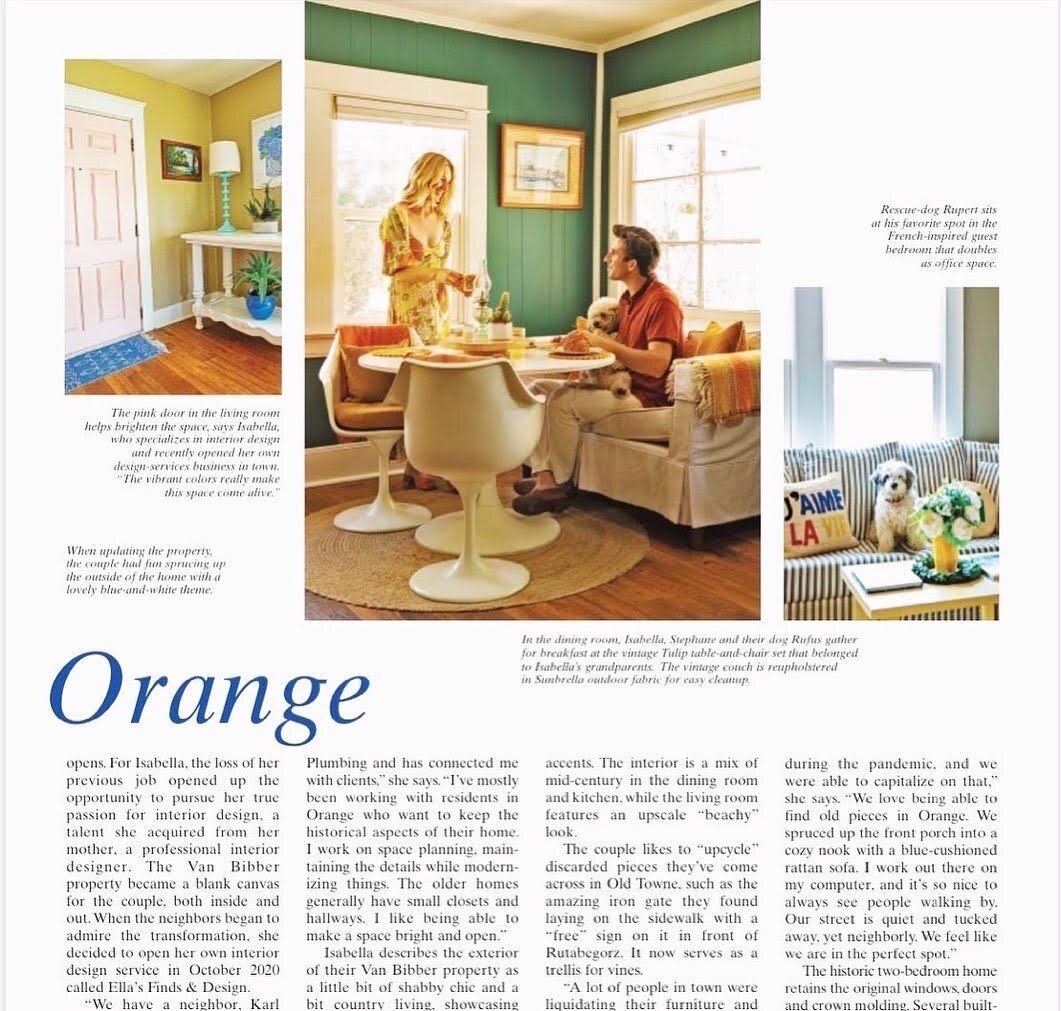 Living room with vintage decor, green walls, white furniture, and a woman with a man and a dog at a dining table. A cozy sitting area with striped couch and dog nearby.
