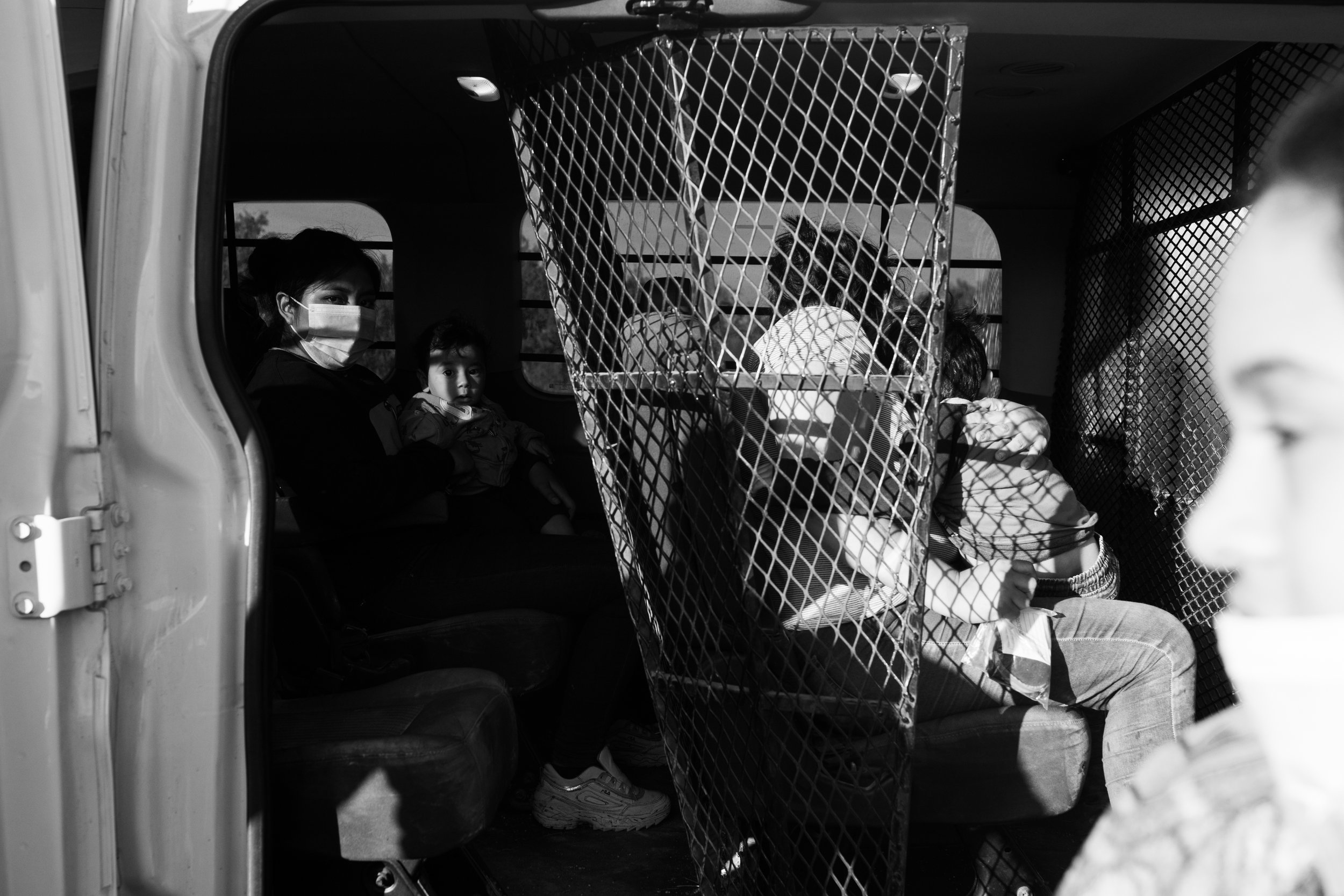  A mother and her child sit waiting to be transported in a Border Patrol vehicle in La Joya, Texas. 