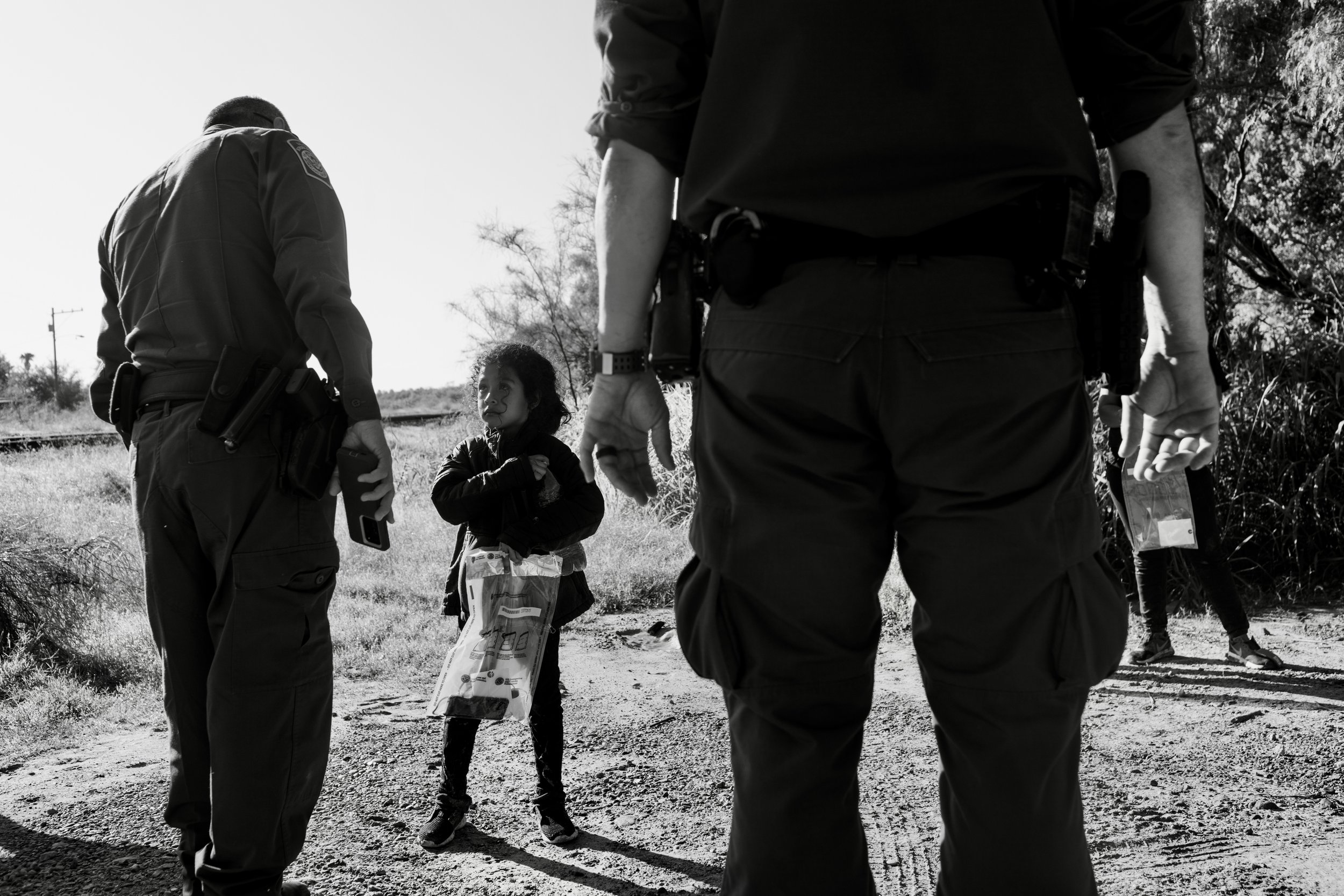  A young unaccompanied minor looks up defiantly at Border Patrol after arriving on American soil in La Joya, Texas. 