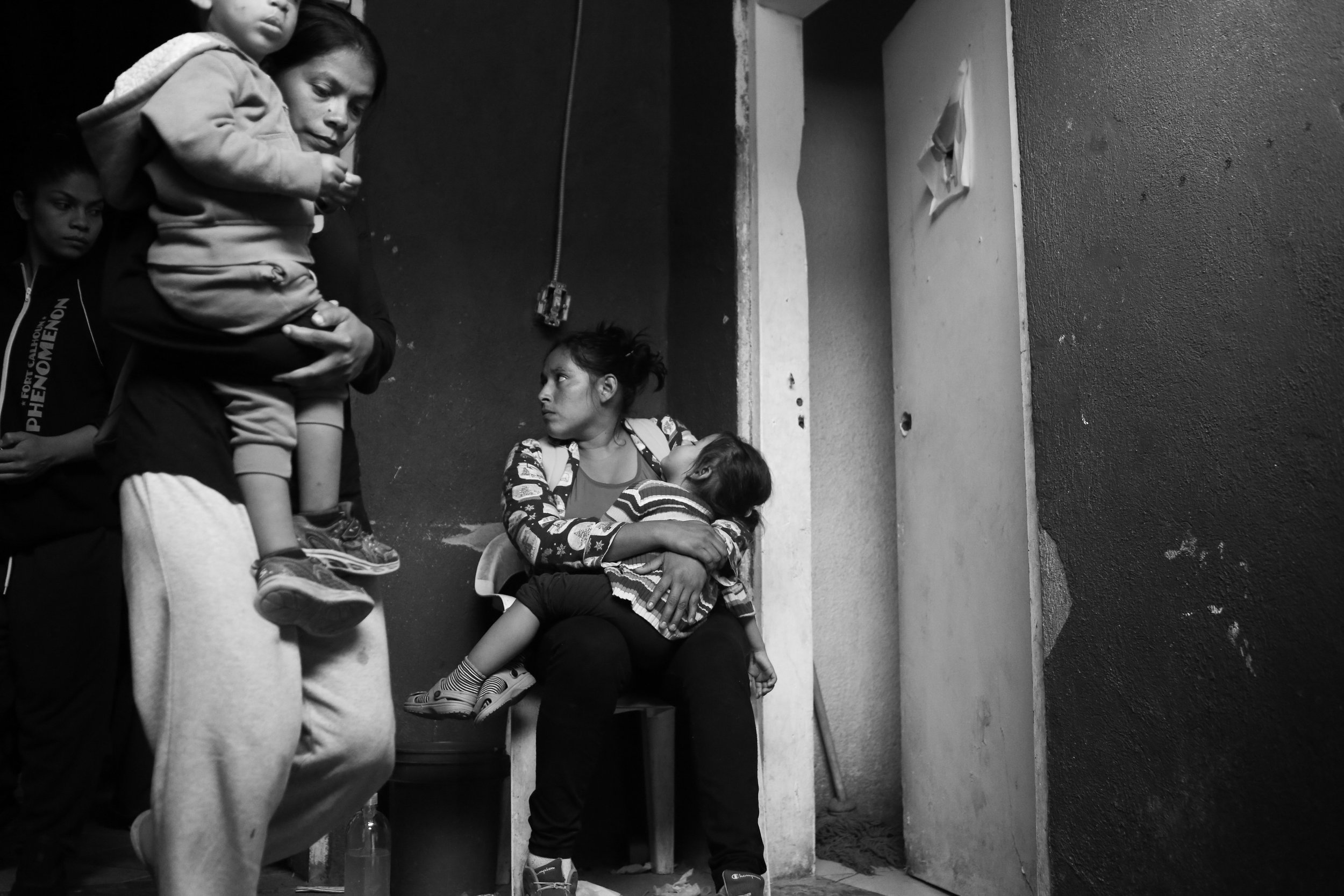 Mothers care for their children in the hallway that connects the communal bathroom and washroom at Inglesa Embajadores se Jesus. 