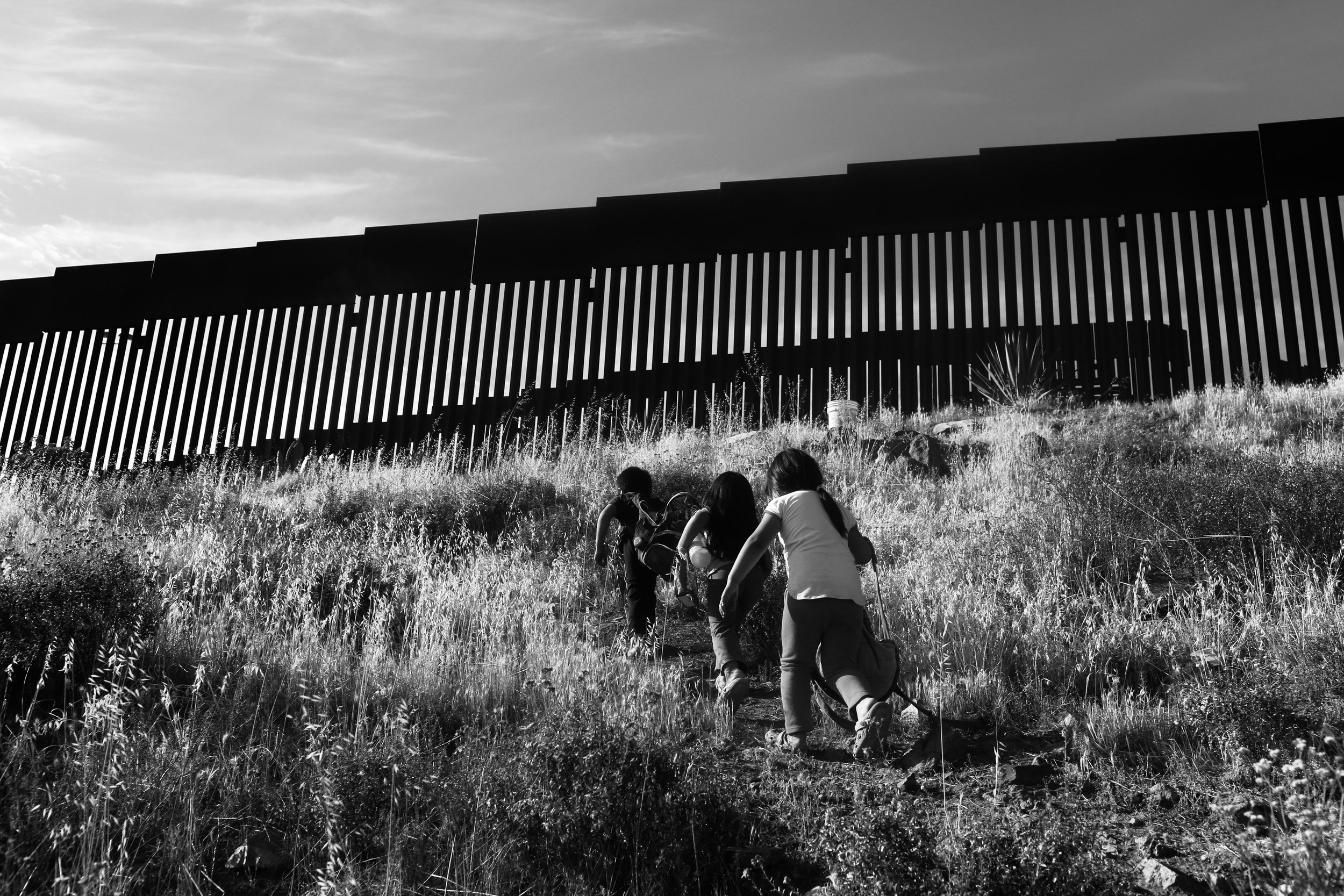  Children run by the break in the the border wall at Eagle’s Pass in Tijuana, Mexico. 