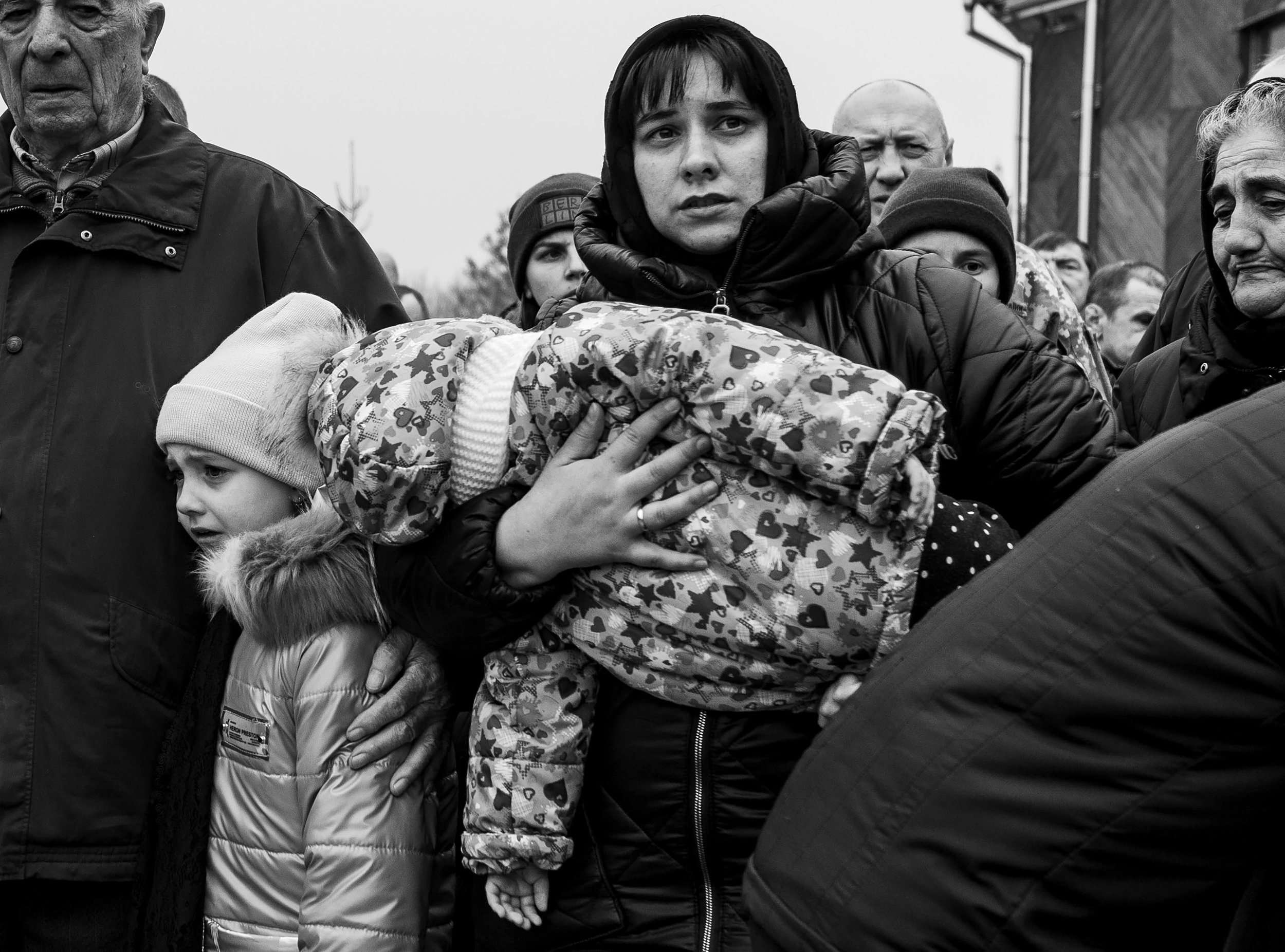  The family of Mykola Dmytrovych and Roman Fedorovich walk through the streets in mourning. The entire town stood on the sides of the road as the procession marched to the gravesite from the church in Starychi, Ukraine. 