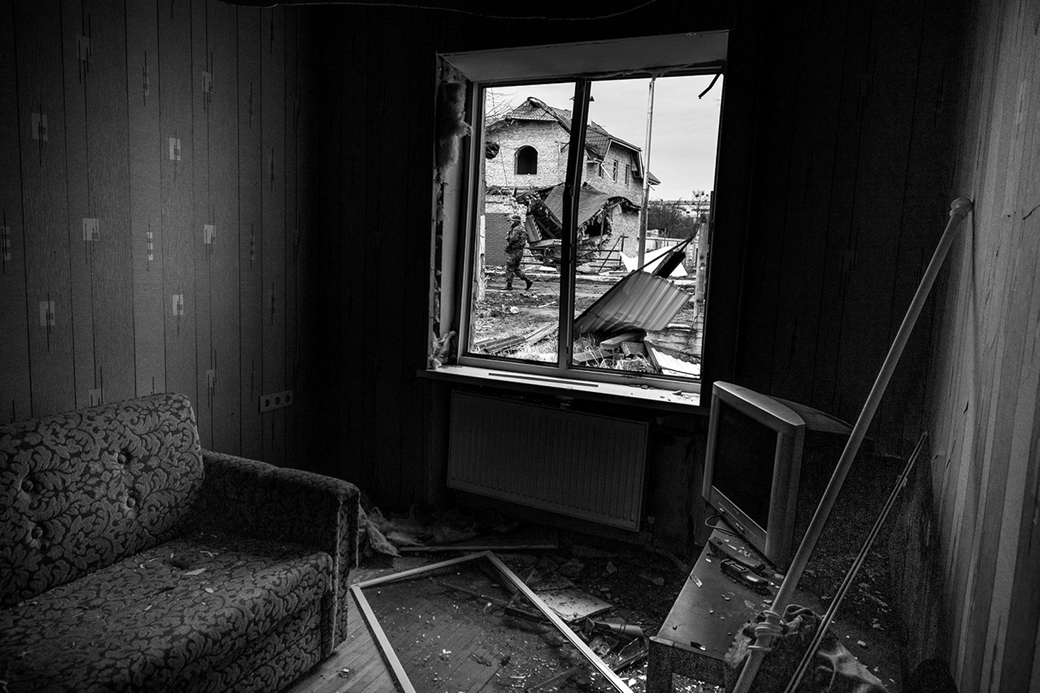  A soldier is visible through the window of a destroyed home in Irpin, Ukraine.  