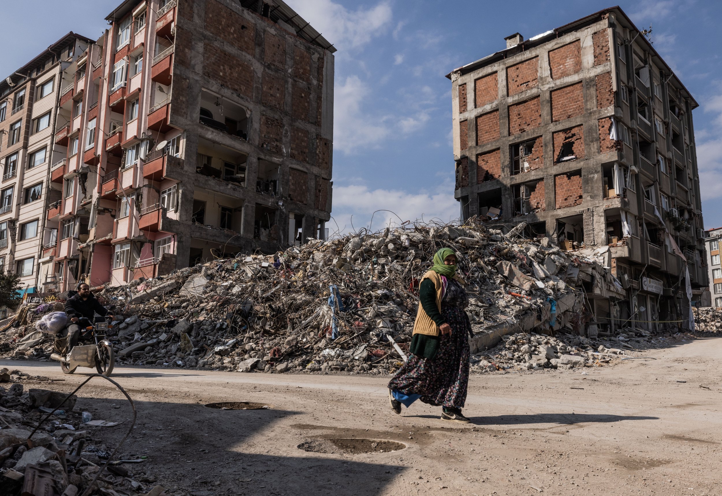  A Turkish woman walks through the rubble in the city center of Hatay, Turkey on February 24, 2023.  