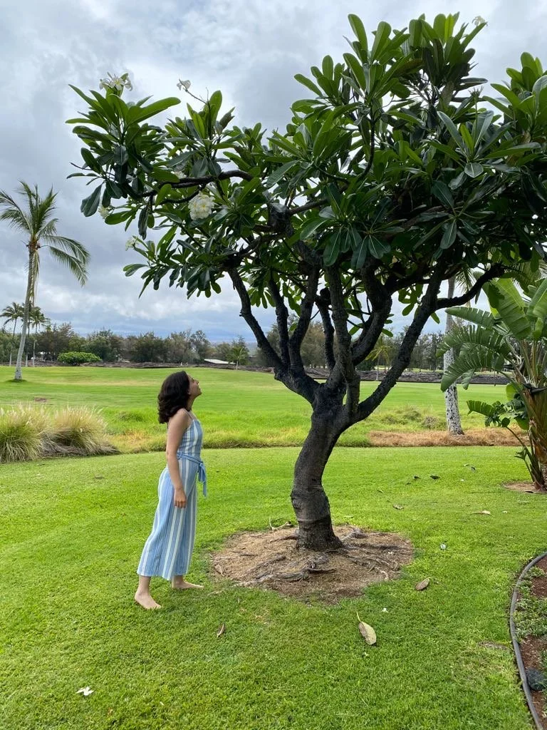 Mariana Luna standing next to a tropical tree on the Big Island of Hawaii