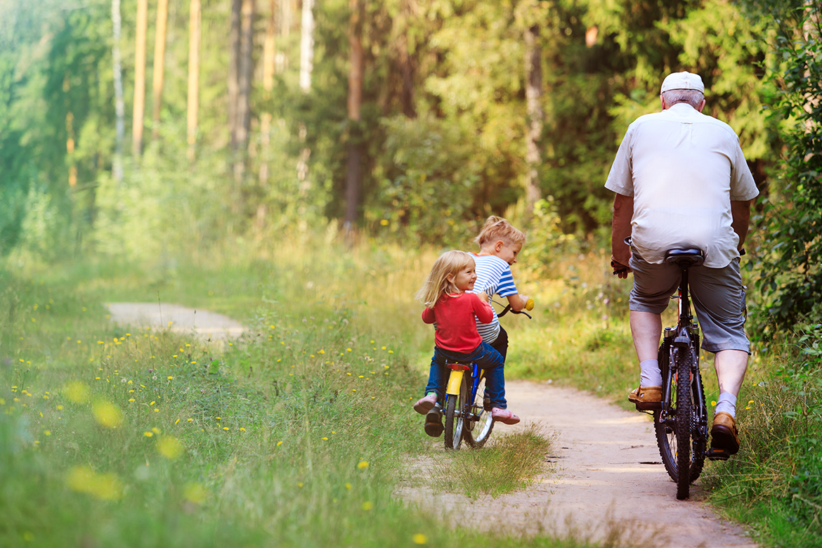 Grandfather rides bike with grandchildren