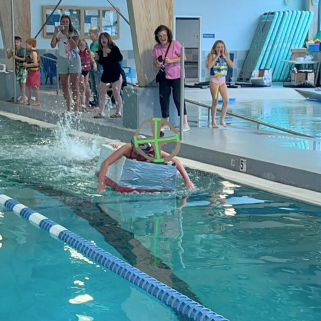 Swim Team boat with fans cheering