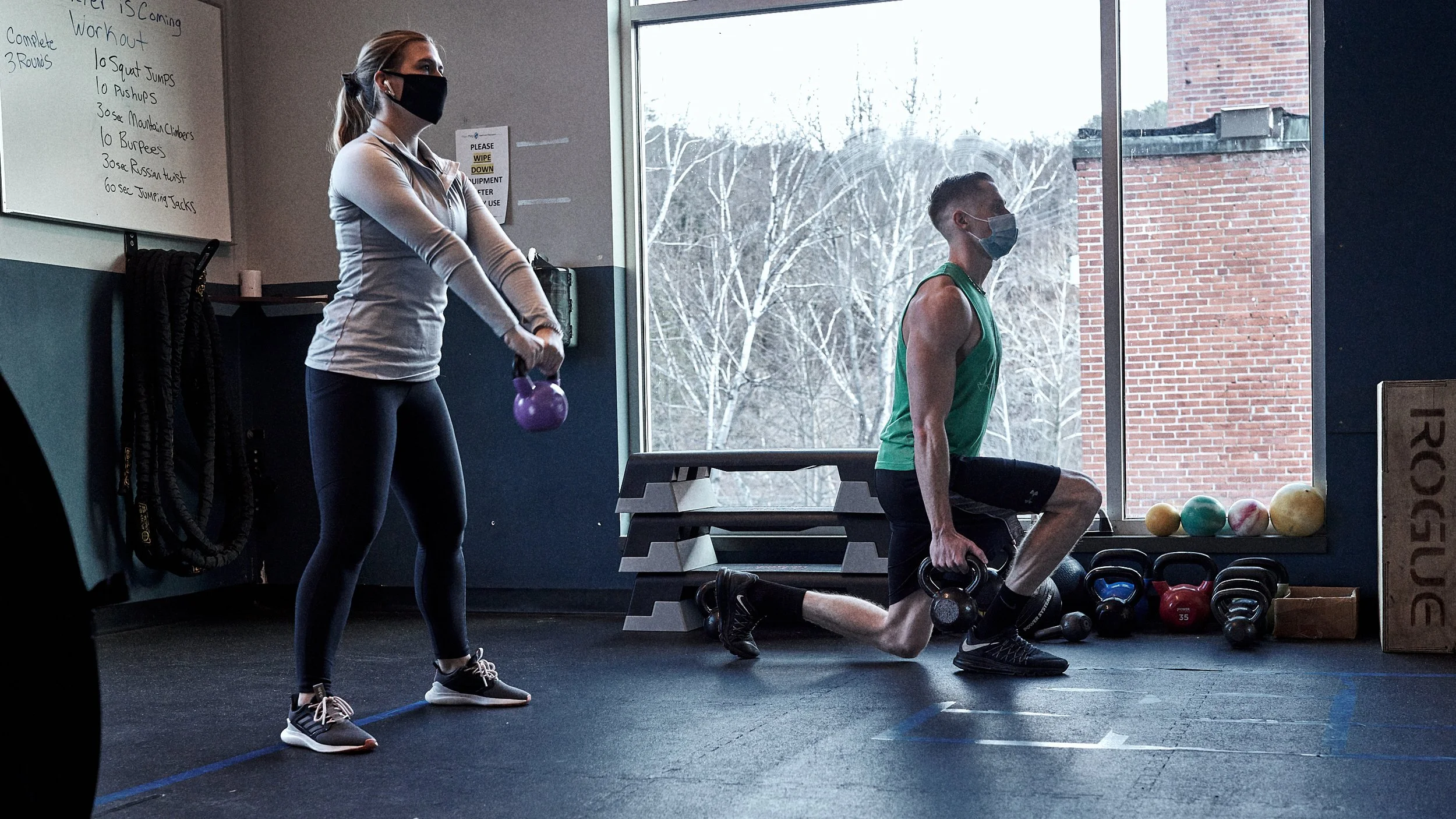 Two adults wearing face masks while working out during Covid