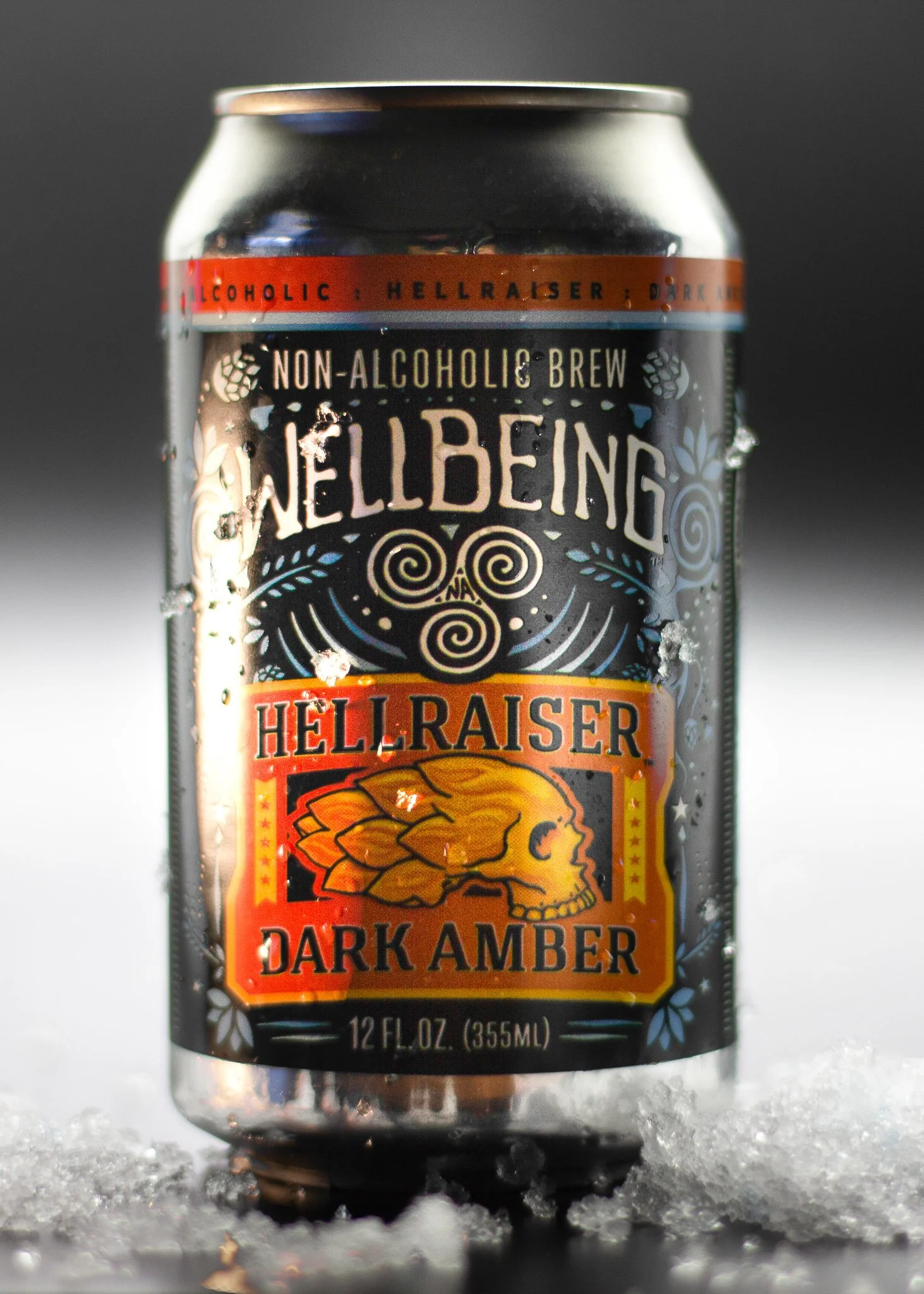 A can of NellBeng Hellraiser Dark Amber non-alcoholic brew with snow around it and a dark background.