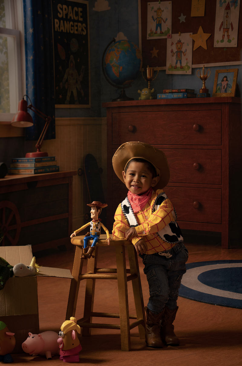 Toddler boy in a Woody costume celebrating his birthday during a Toy Story mini session in an Andy’s Room studio setup in Clarksville, TN