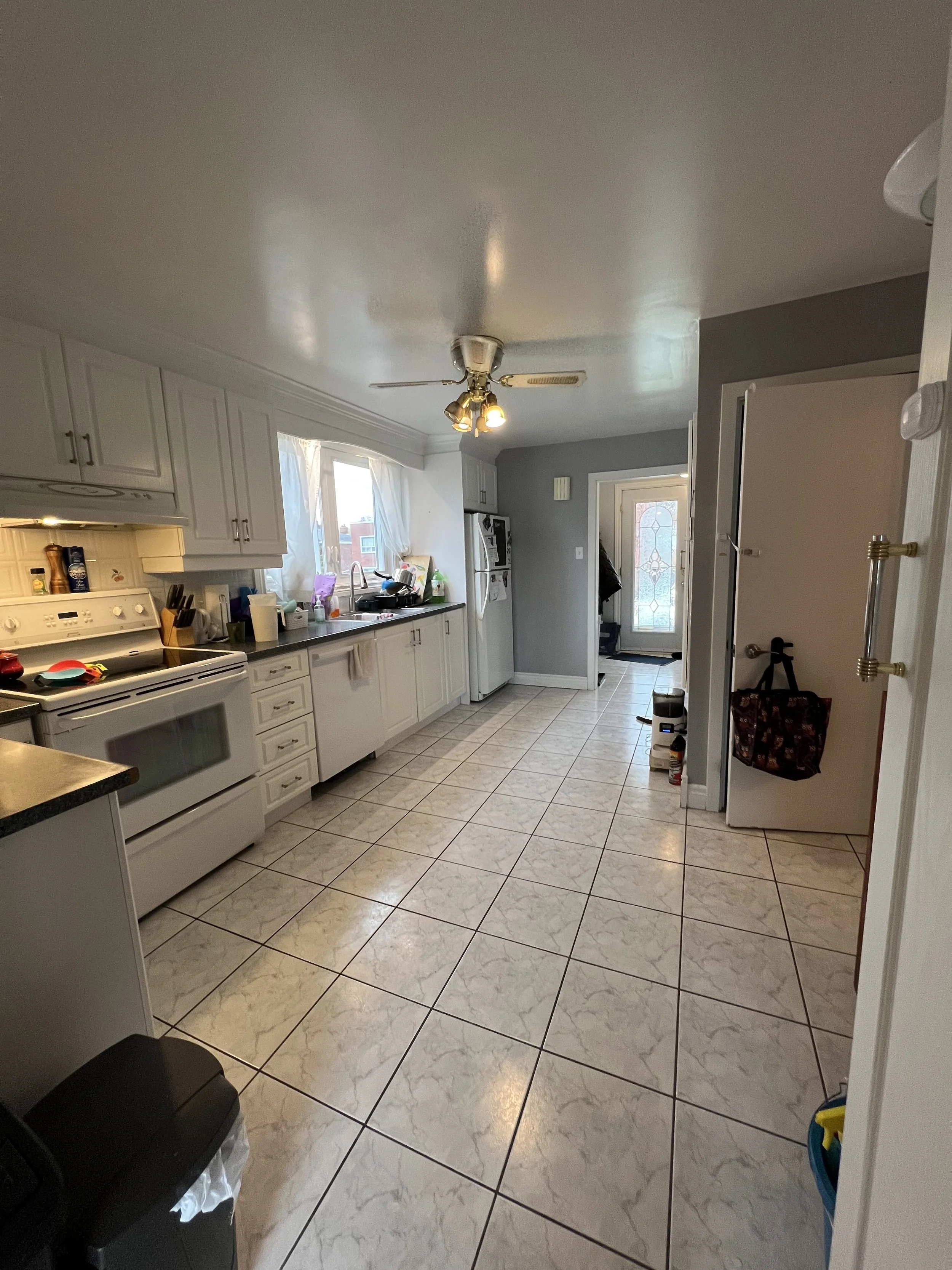 Kitchen with white cabinets, a white stove, and a window above the sink.