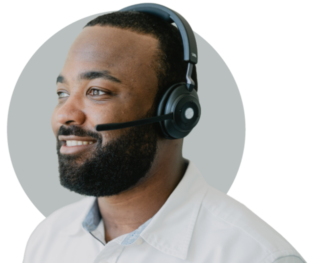 Close-up of a smiling man wearing a white shirt and a black headset with a microphone.
