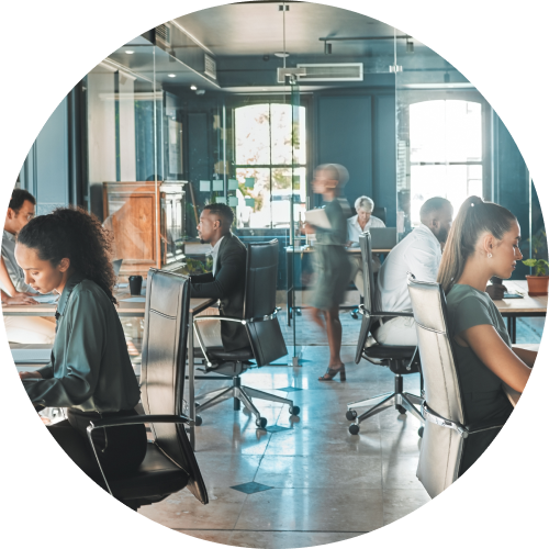 Employees collaborating at desks in a modern open-plan office