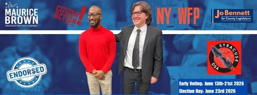 Two men standing side by side at a political campaign event. The man on the left wears a red sweater and khaki pants, and the man on the right wears a gray suit with a white shirt and patterned tie. The background features campaign logos, endorsements, and voting information for Maurice Brown and Jo Bennett, with dates for early voting and election day in June 2026.