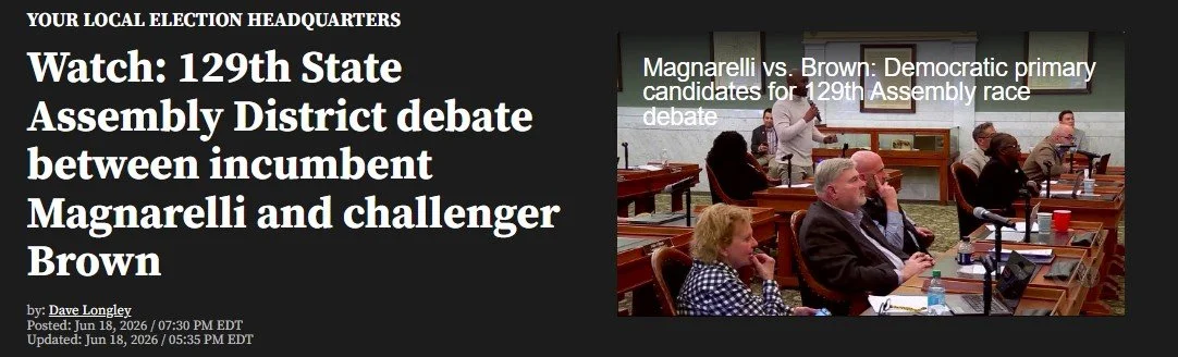 A headline about a debate between Magarelli and Brown at the 129th State Assembly District, with a photo of people seated at desks in a room, participating in the debate.
