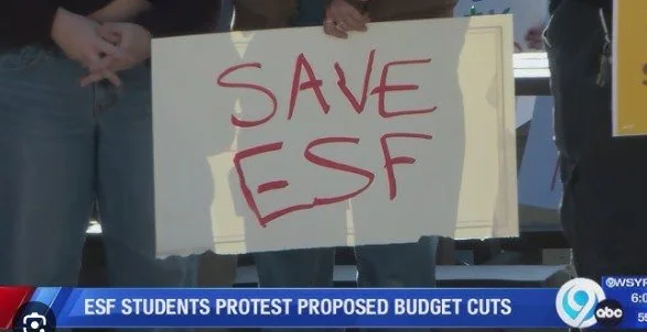 Protesters holding a sign that reads 'SAVE ESF' during a demonstration against proposed budget cuts to ESF students.