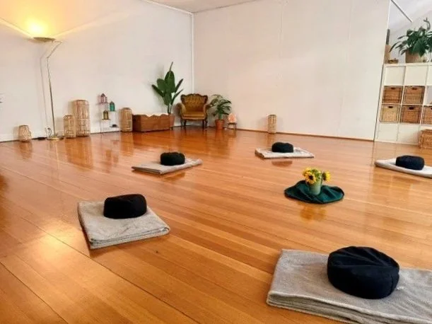 Gruppenraum mit Holzboden, Decken und Meditationskissen