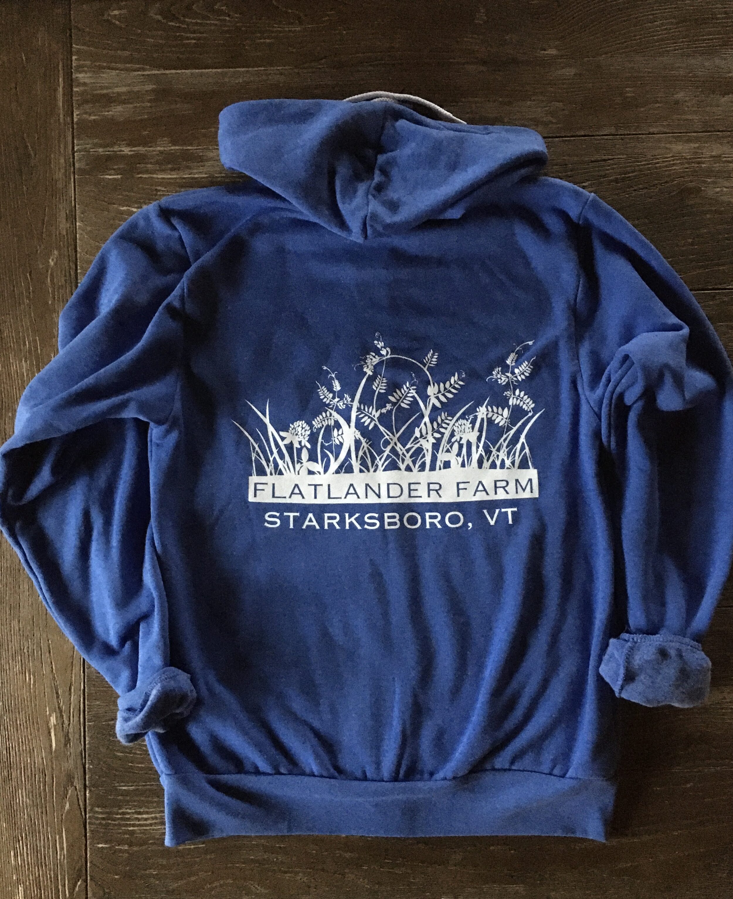 back of blue Flatlander Farm zip up sweater